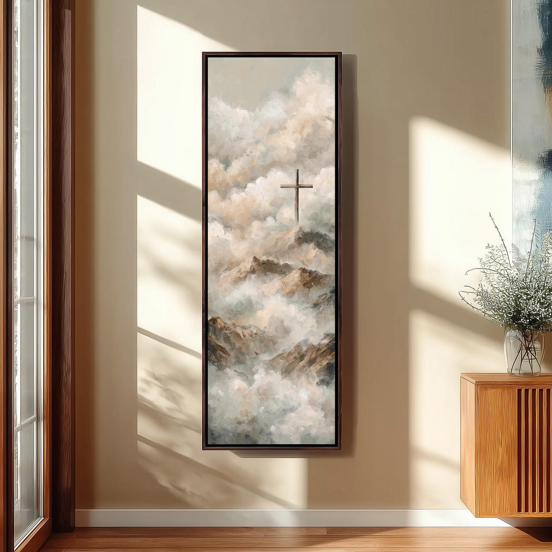 a serene bedroom scene with a large painting of clouds and a cross hanging on the wall. The painting is framed in a white frame and is the focal point of the room. The room features a bed with white bedding, a wicker ottoman, and a potted plant. The overall color scheme of the room is neutral, with the white frame and the painting adding a touch of color and contrast.