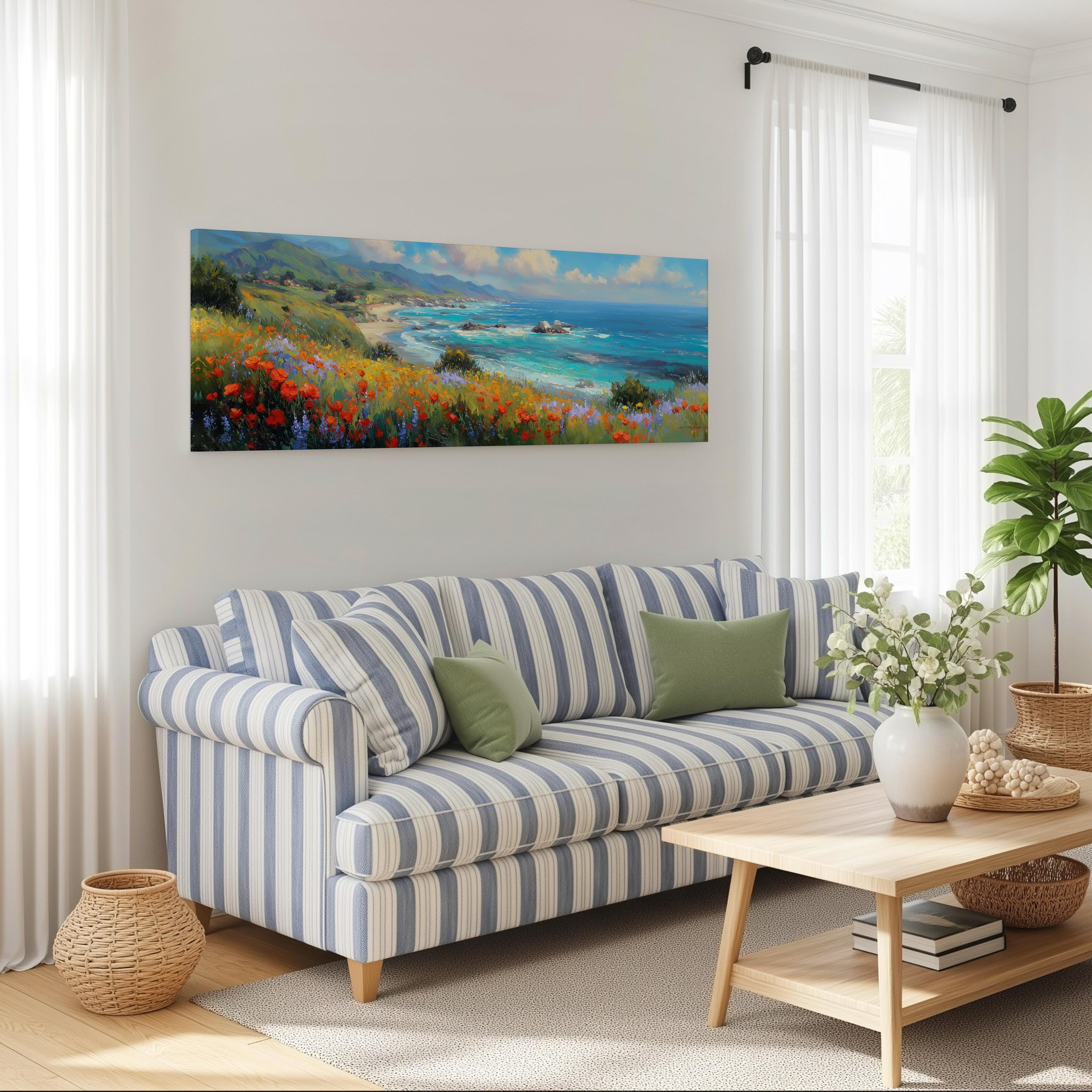 a living room with a striped blue and white sofa, a wooden coffee table, and a large painting of a coastal landscape hanging on the wall above the sofa.