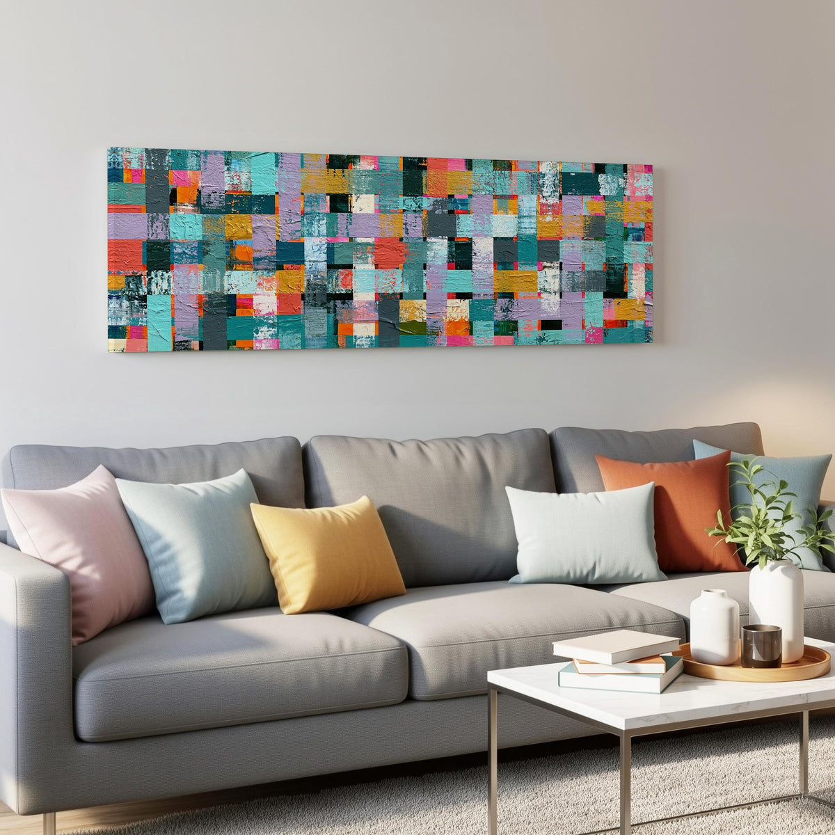 Woven grid of teal and pink blocks panoramic canvas print above a grey sofa in a living room