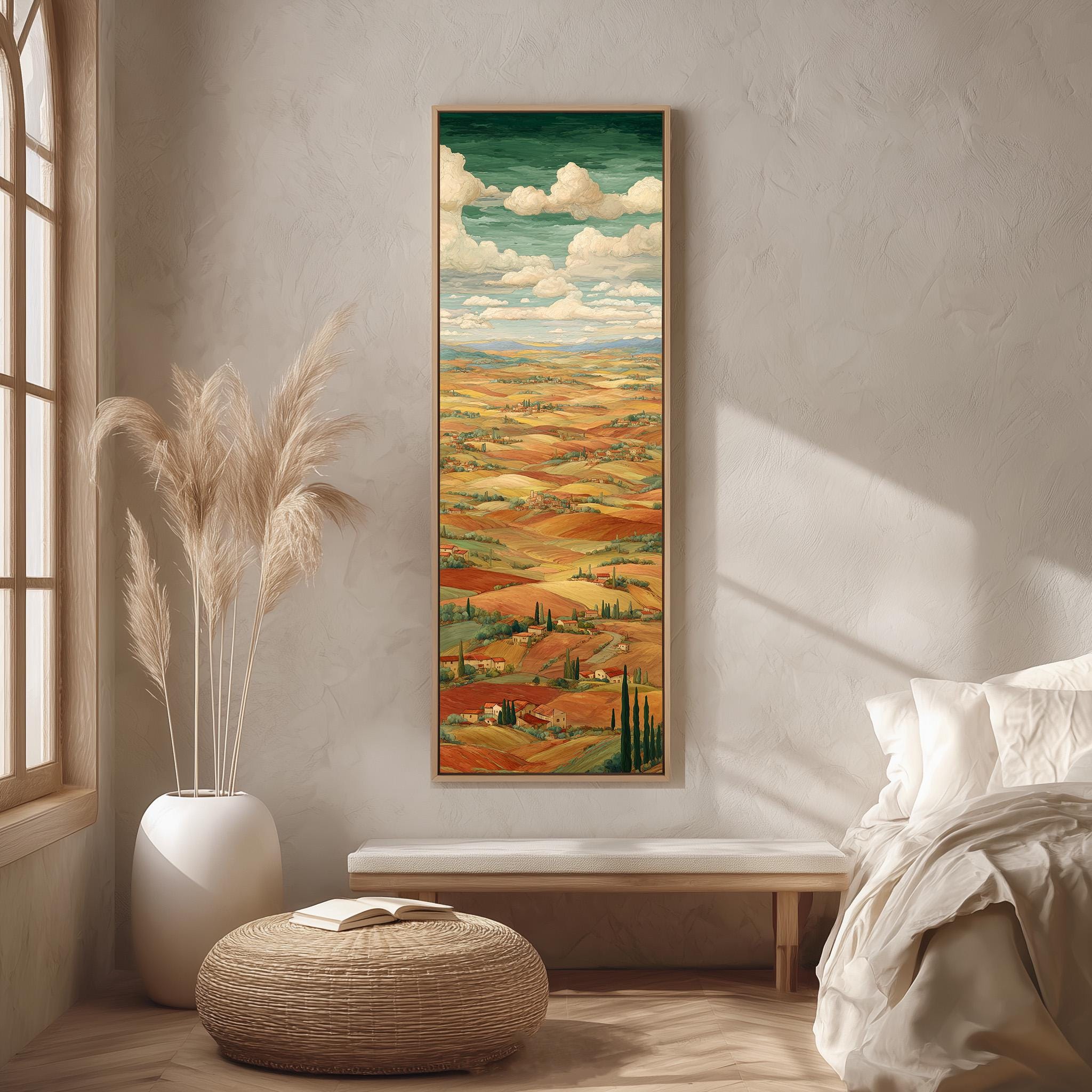 a large painting of a countryside landscape hanging on a wall in a room with a bed, a potted plant, and a woven ottoman.