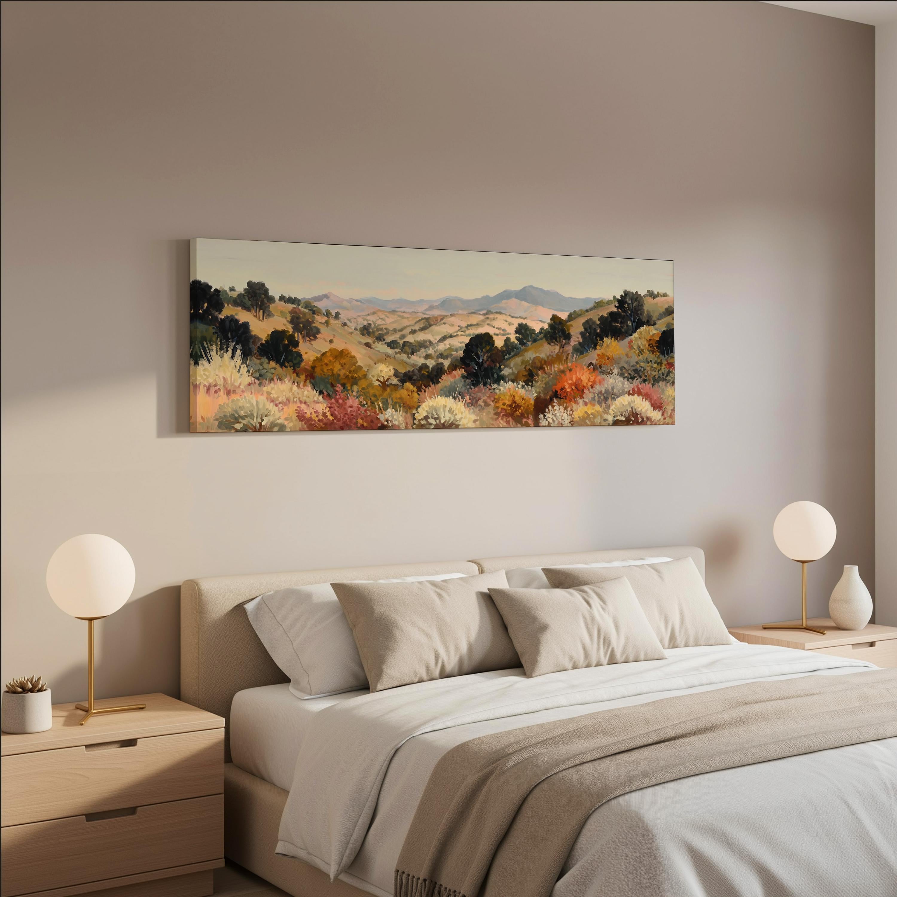 a serene bedroom scene with a large bed adorned with white linens and beige throw pillows. Above the bed, a large landscape painting hangs on the wall, featuring a picturesque countryside with rolling hills and trees in various shades of green, orange, and yellow. The room is decorated with two round table lamps on nightstands, and the overall color scheme is neutral, creating a calm and peaceful atmosphere.