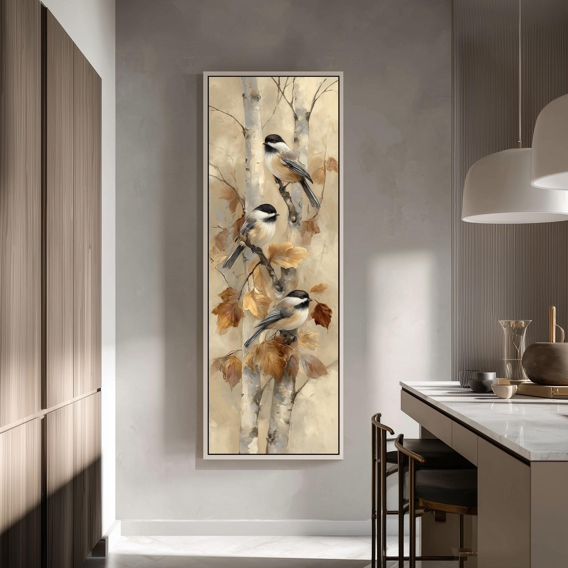 a large painting of two birds perched on a tree branch, with autumn leaves in the background. The painting is hung on a wall in a room with a kitchen counter and chairs visible in the background.