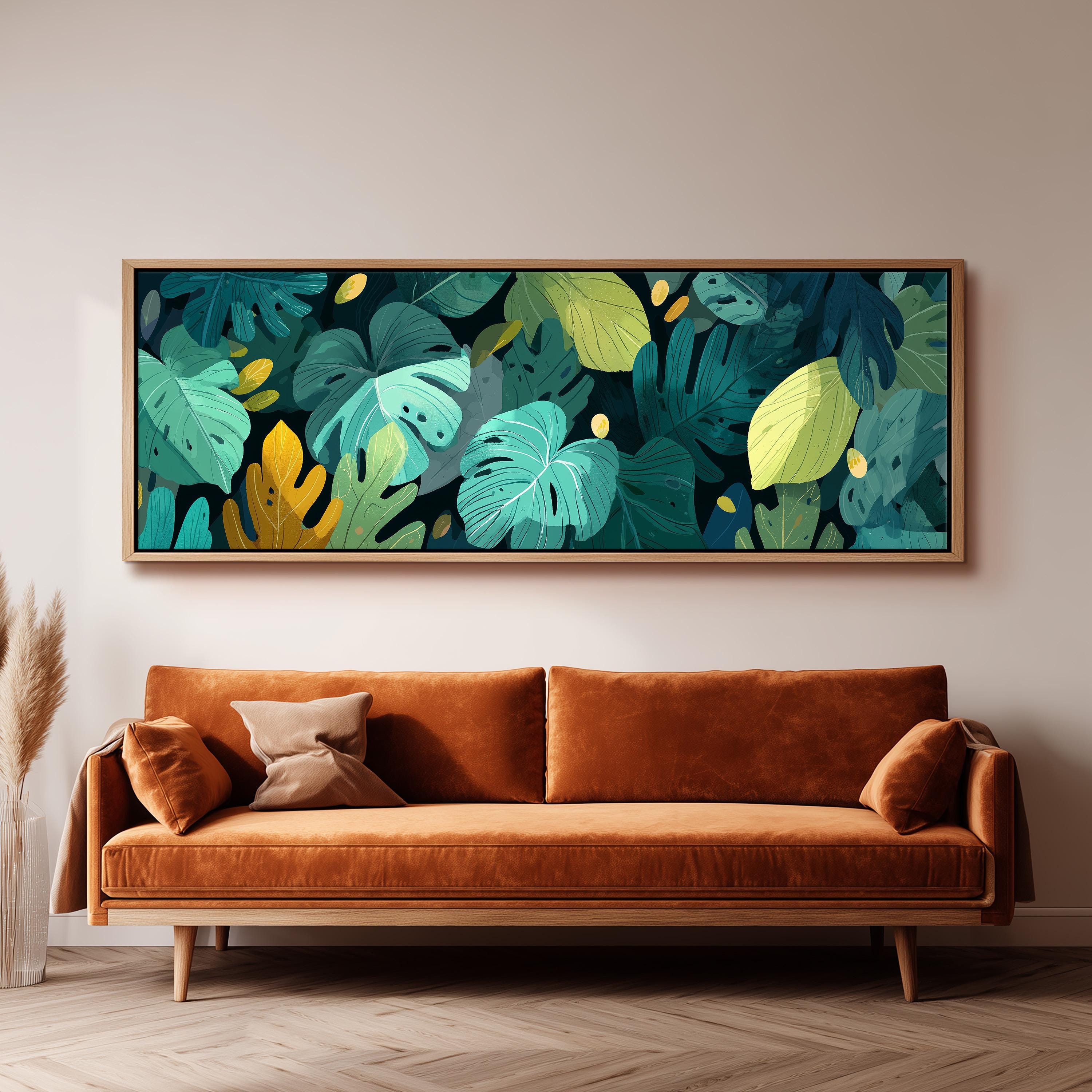 a large, framed artwork of tropical leaves hanging on a wall above a brown sofa in a living room setting.