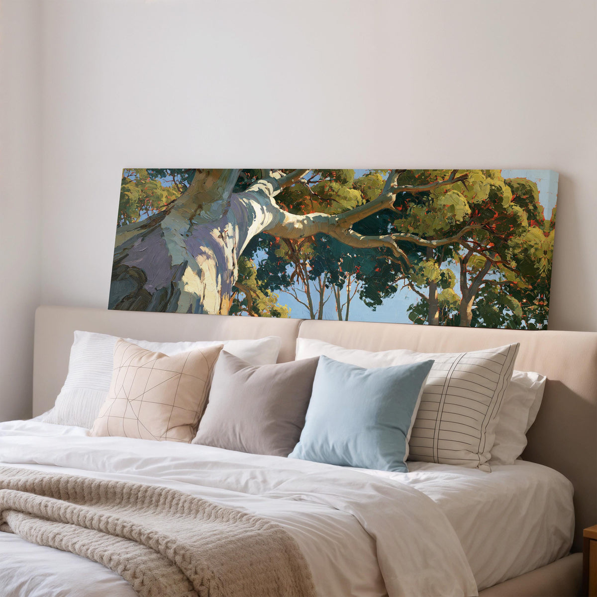 Sunlit eucalyptus trunk and branches wide panoramic canvas print above a bed in a bedroom