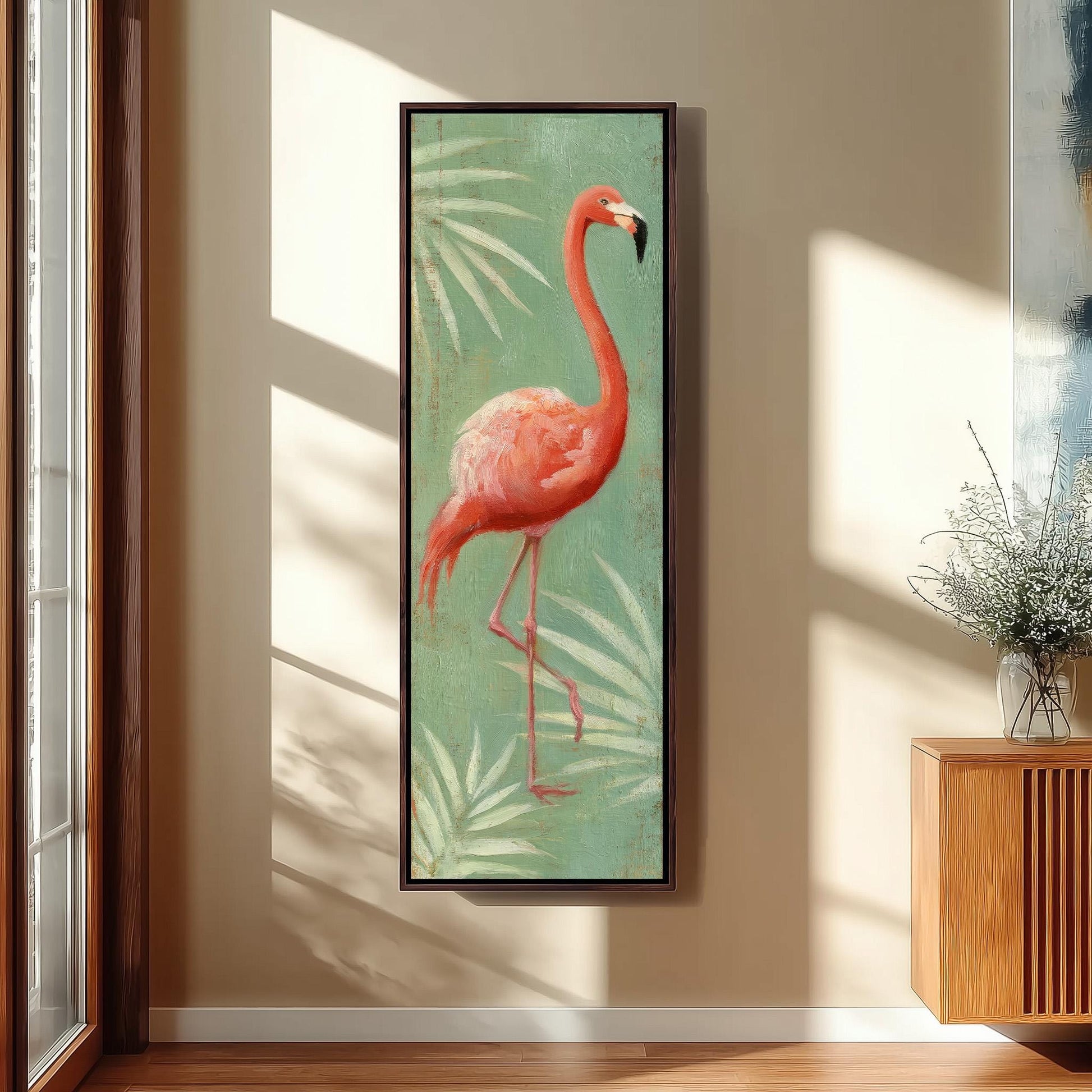 a large framed painting of a flamingo standing on one leg against a green background with white leaves.