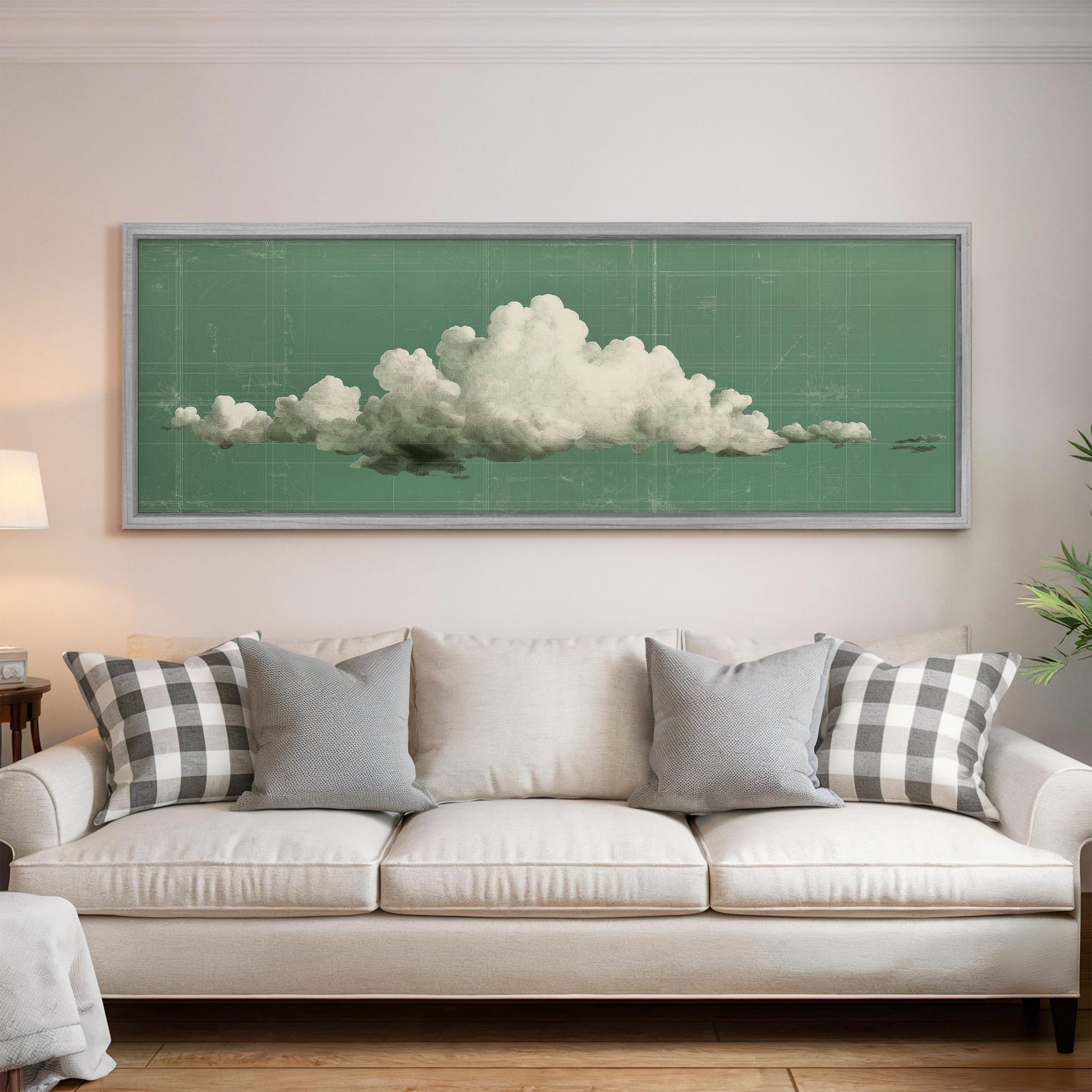 a large framed picture of a cloud hanging on a wall above a white couch with gray and black plaid throw pillows.