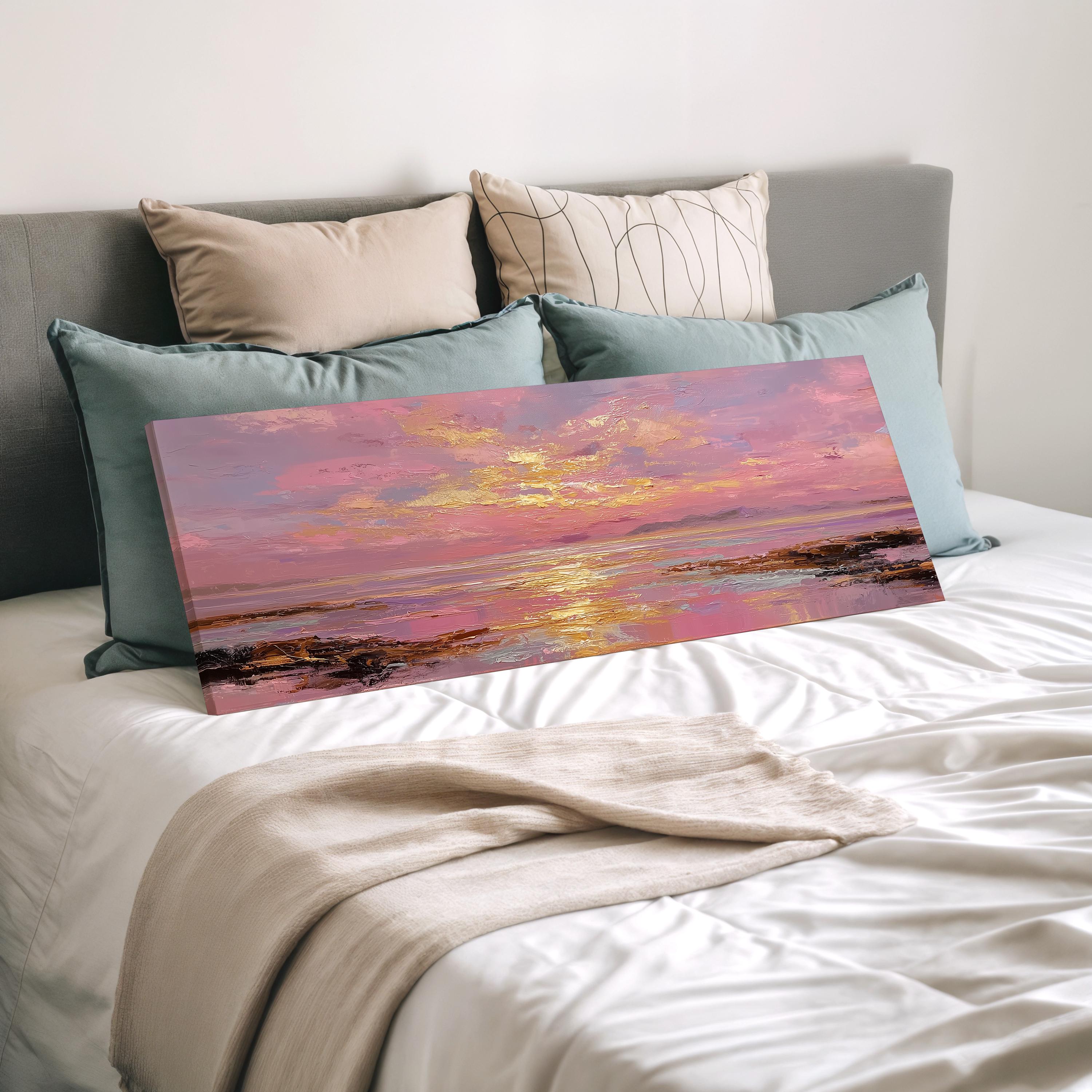 a large painting of a sunset over a body of water, displayed on a bed with a white comforter and pillows.