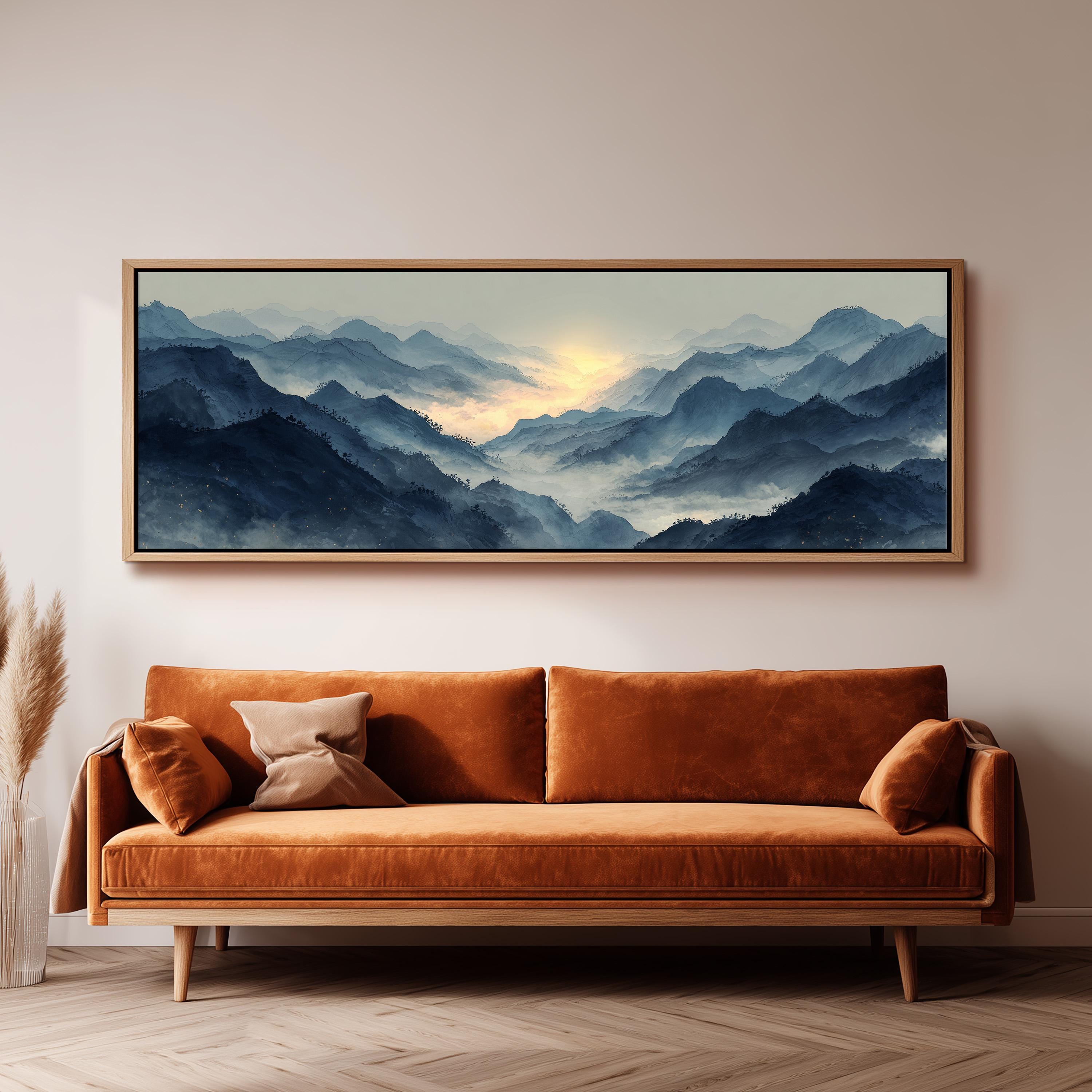 a large, framed painting of a mountainous landscape hanging on a wall above a brown sofa.