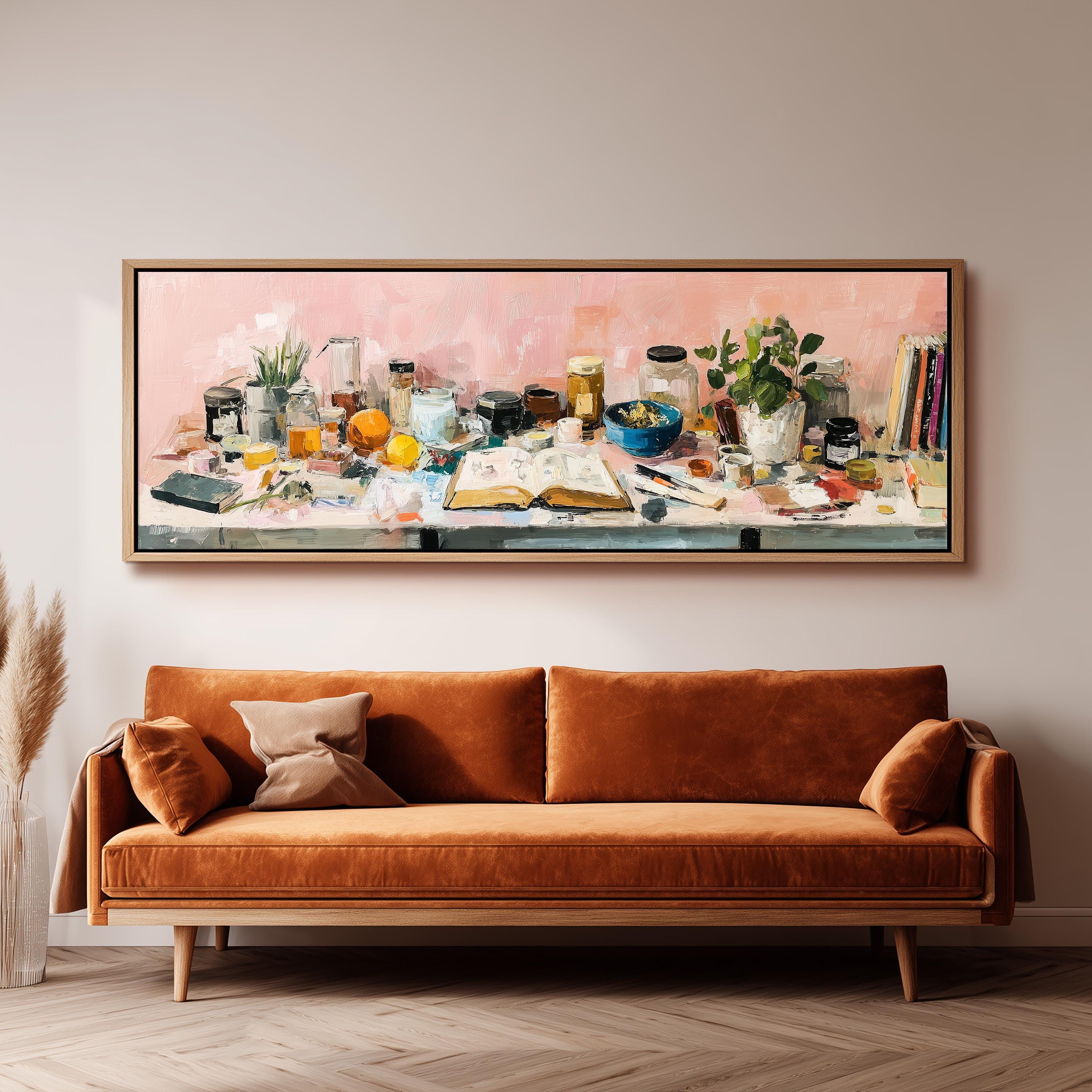 a large painting of a table with various objects, including a vase, a bowl, a book, and a plant, displayed on a wall above a brown sofa.