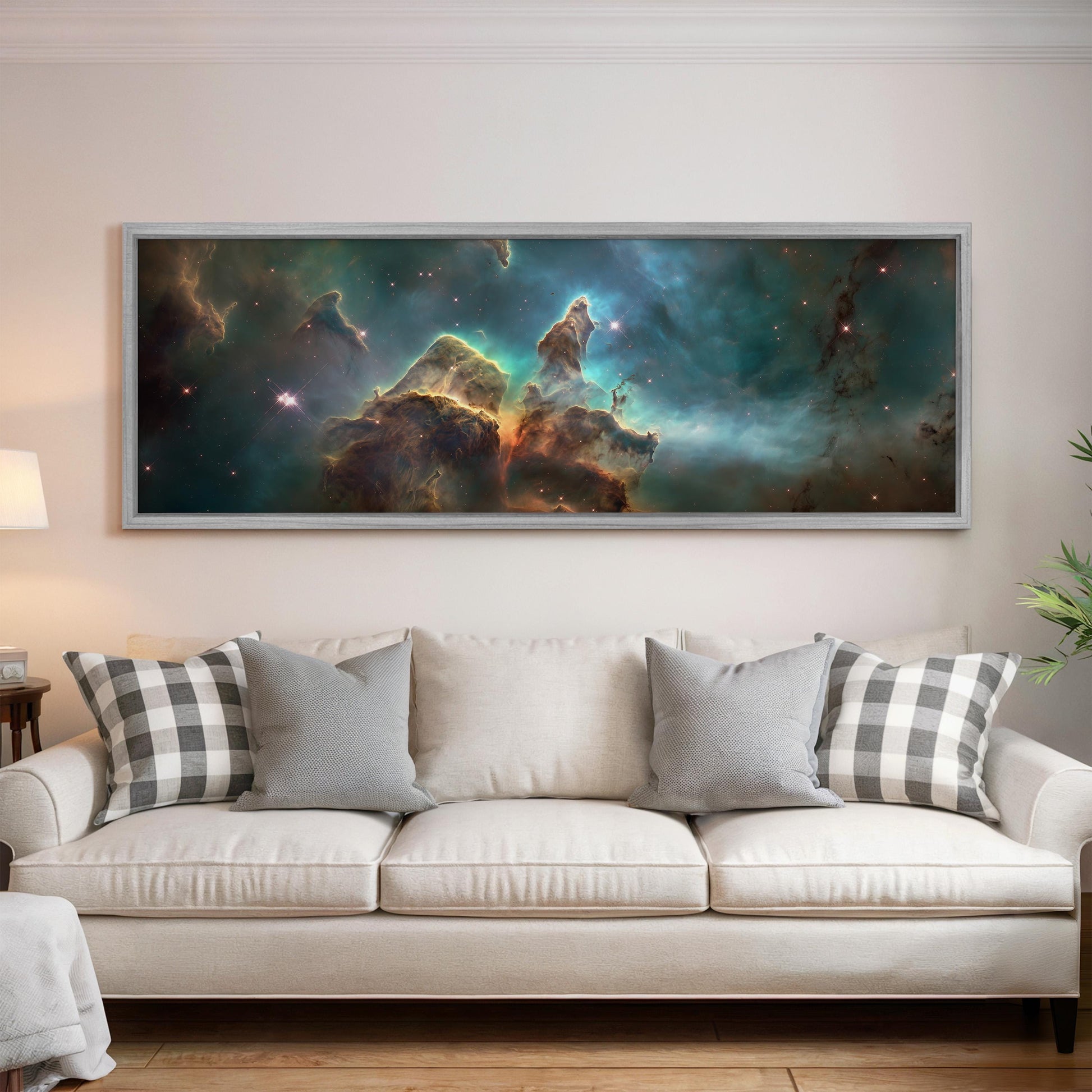 a large, framed painting of a nebula hanging on a wall above a white couch with gray and white plaid throw pillows.