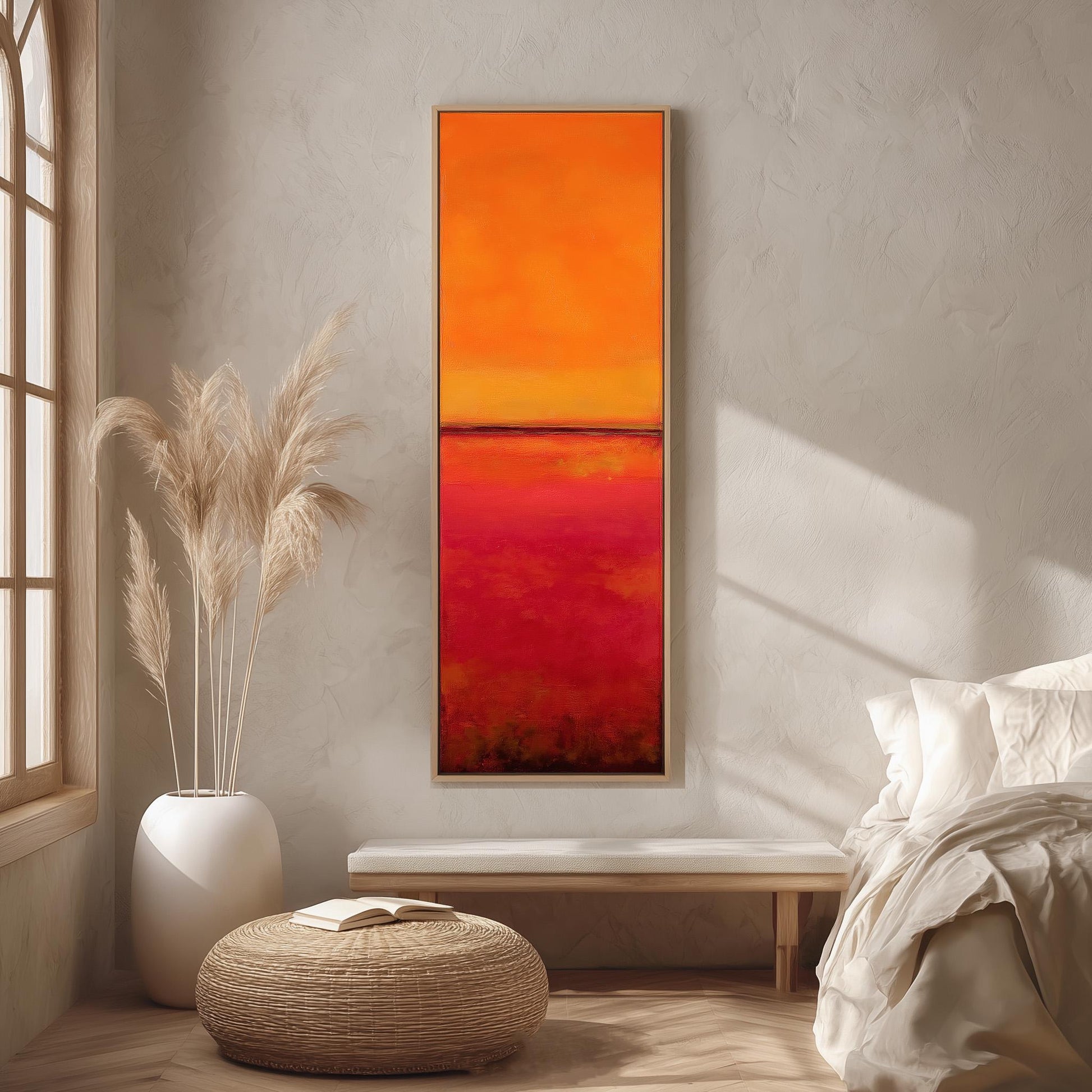 a modern bedroom with a large, vibrant painting of a sunset on the wall. The painting is framed in a wooden frame and hangs above a white bench. The room has a minimalist and clean design, with a large window providing natural light and a white ottoman in the center.