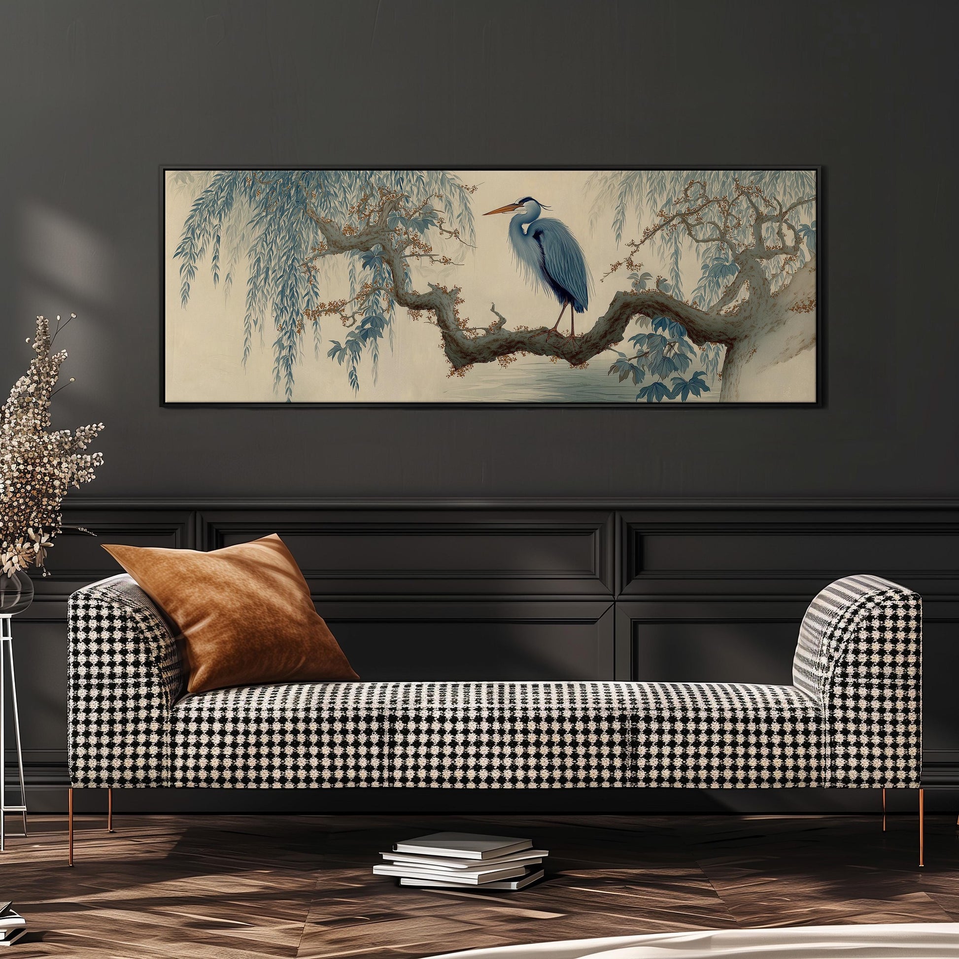 a large, framed painting of a blue heron perched on a branch, hanging on a wall above a black and white checkered sofa.