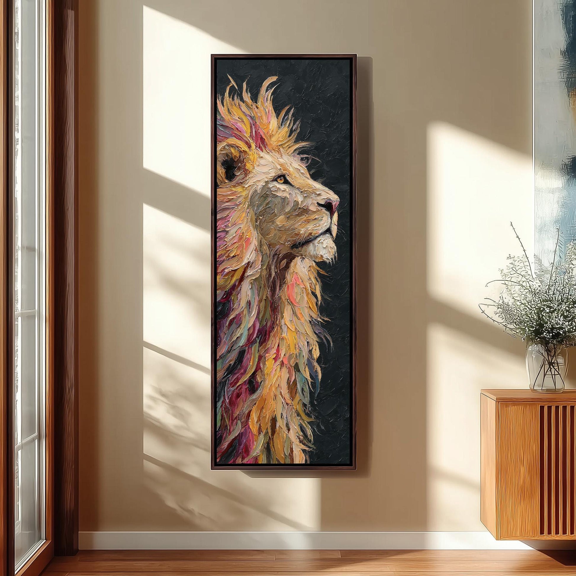 a large, colorful painting of a lion's head hanging on a wall in a room with a wooden cabinet and a vase of flowers.