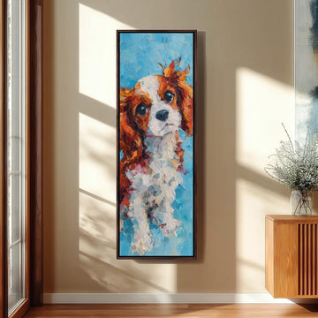 a large, colorful painting of a dog, specifically a Cavalier King Charles Spaniel, hanging on a wall in a room with a wooden cabinet and a vase of flowers.