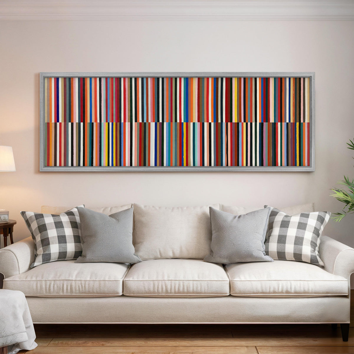 Two bands of colorful stripes panoramic canvas print above a white sofa in a bright living room
