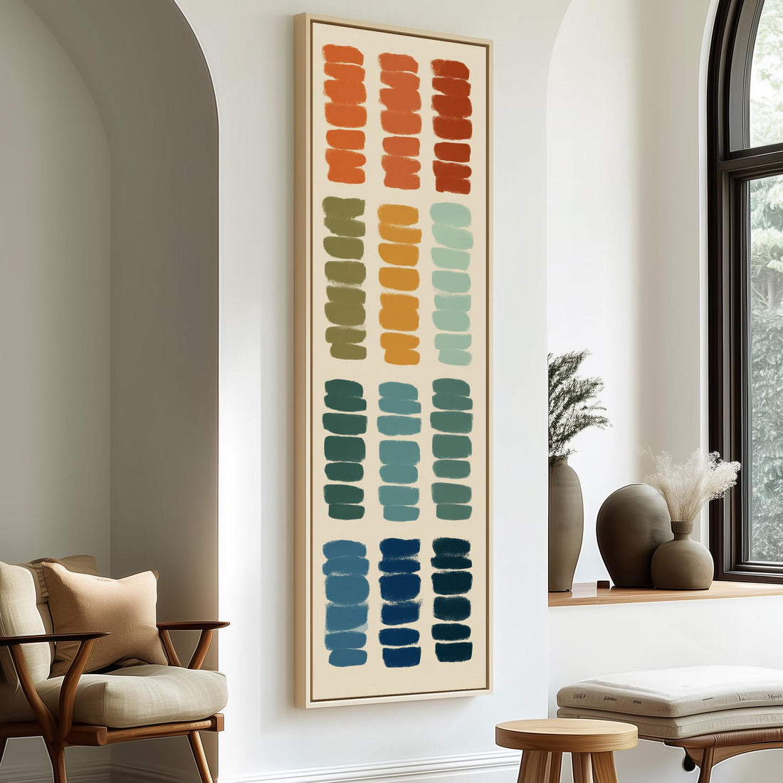 a large abstract painting hanging on a wall, with a wooden cabinet and a vase of flowers to the right of the painting.