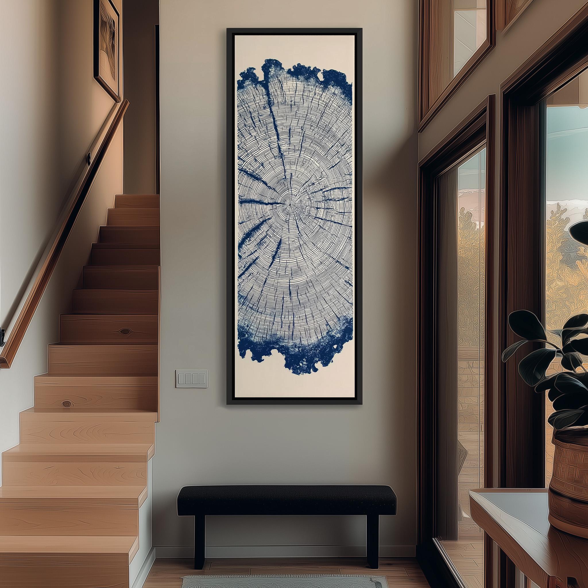 a hallway with a large tree trunk print artwork hanging on the wall, a wooden staircase, a black bench, and a potted plant.