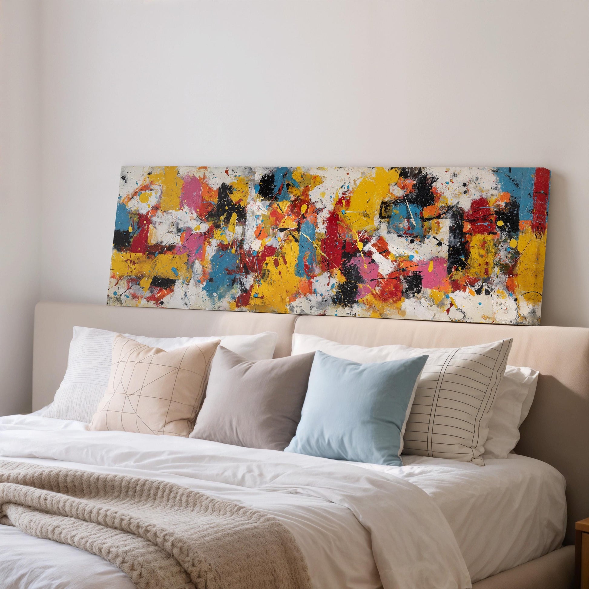 a large, colorful abstract painting displayed on a wall above a bed with white bedding and pillows.