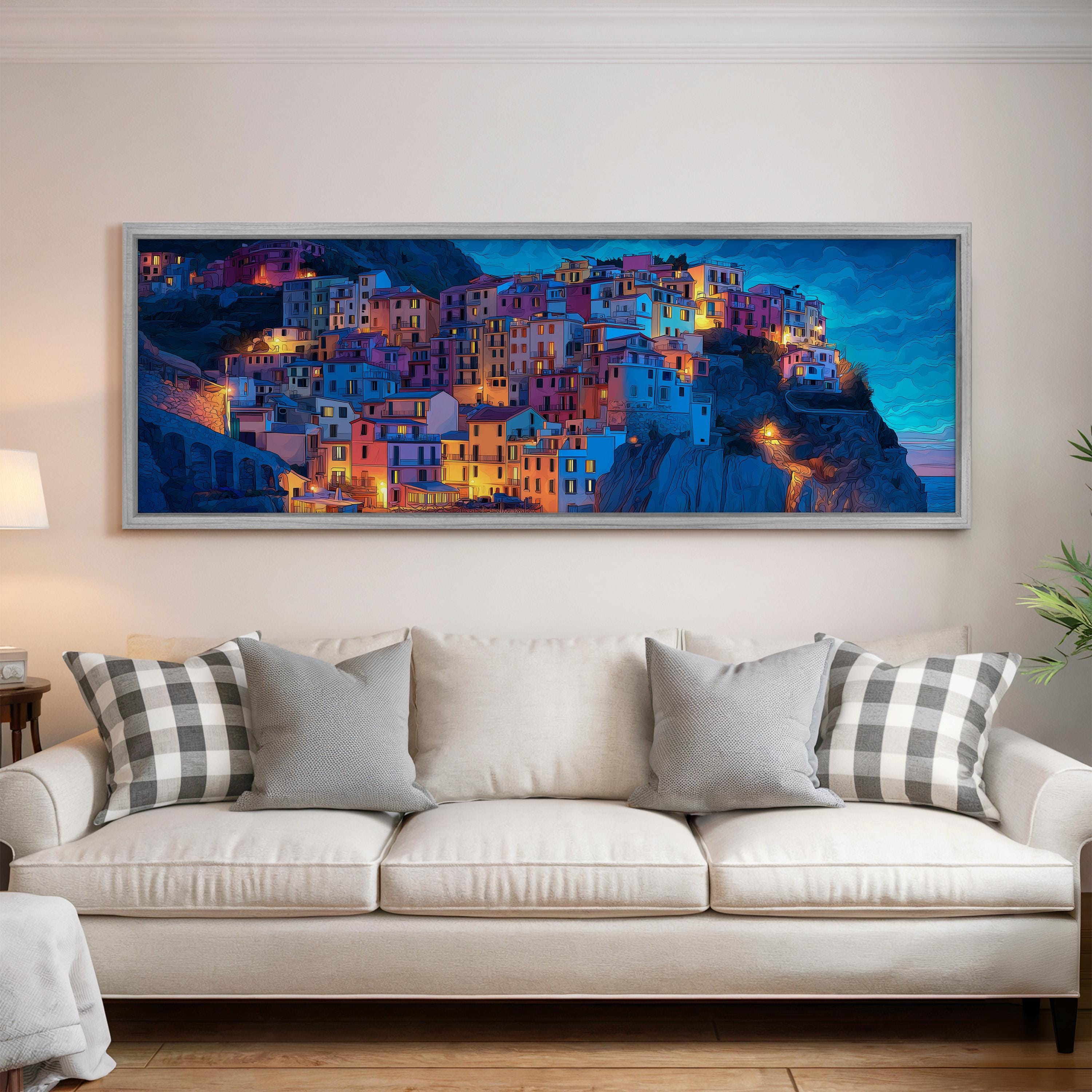 a large, colorful painting of a town on a wall above a white couch with patterned throw pillows.