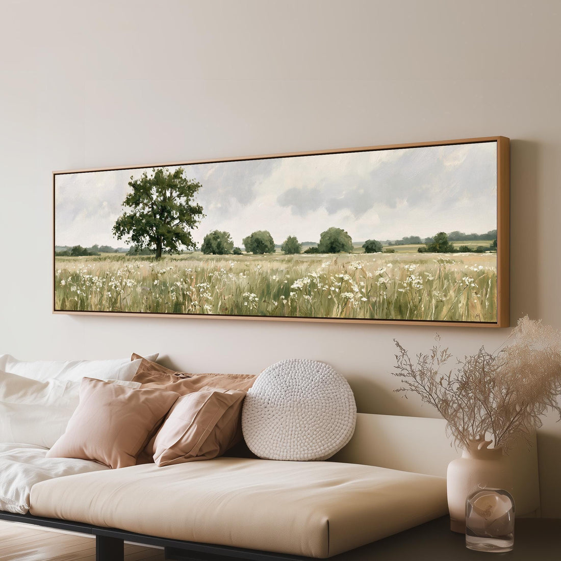 Lone oak tree in a daisy meadow long horizontal canvas print above a sofa in a living room