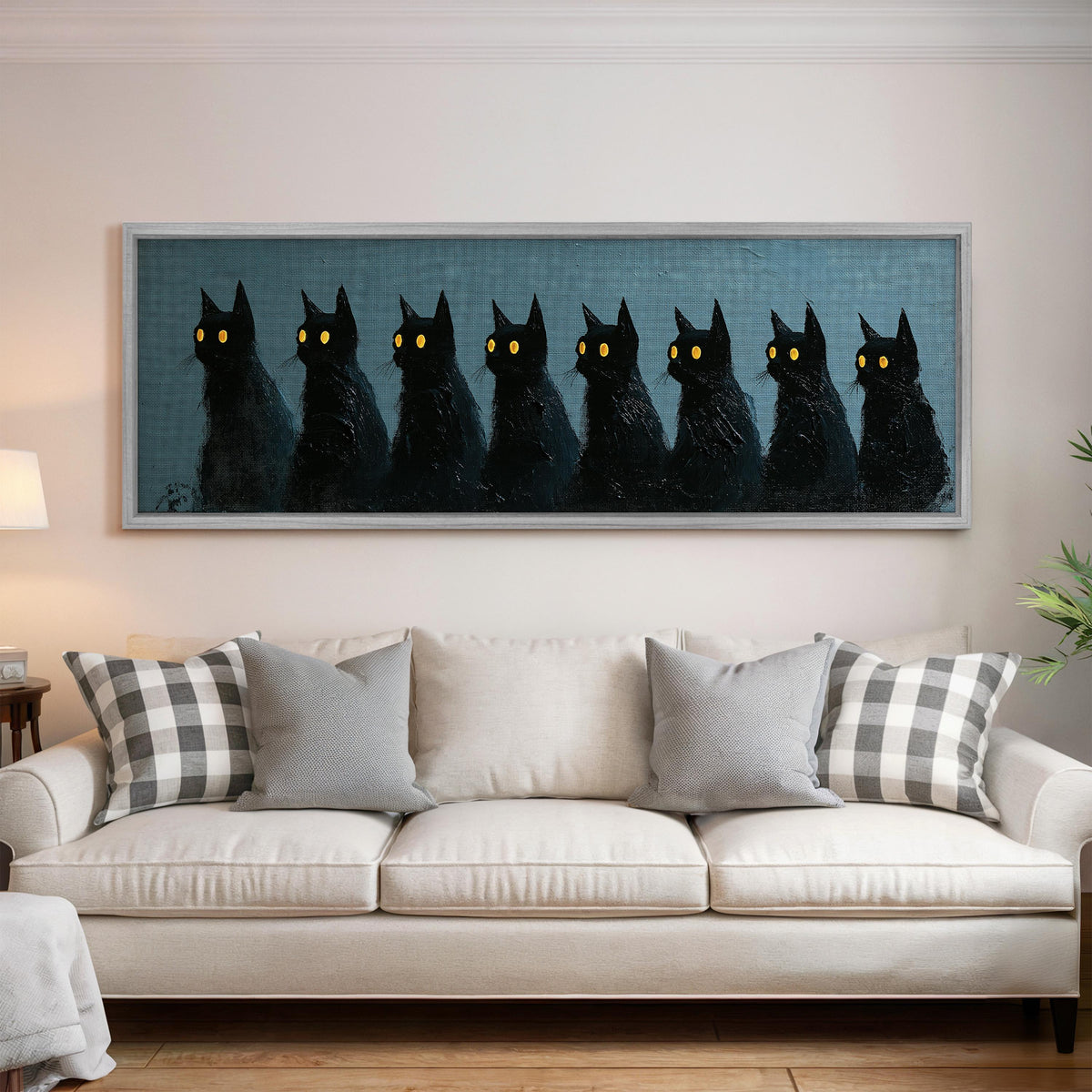 Row of black cats with glowing eyes panoramic canvas print above a white sofa in a bright living room