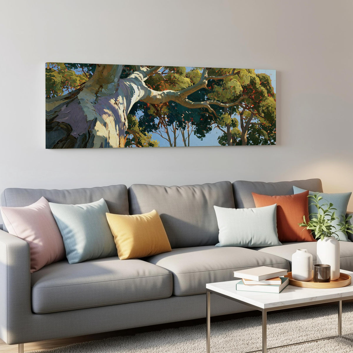 Sunlit eucalyptus trunk and branches panoramic canvas print above a grey sofa in a living room