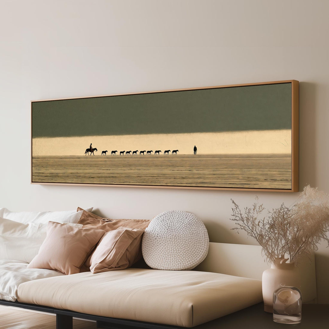 Cowboy leading a line of horses across the desert long horizontal canvas print above a sofa in a living room