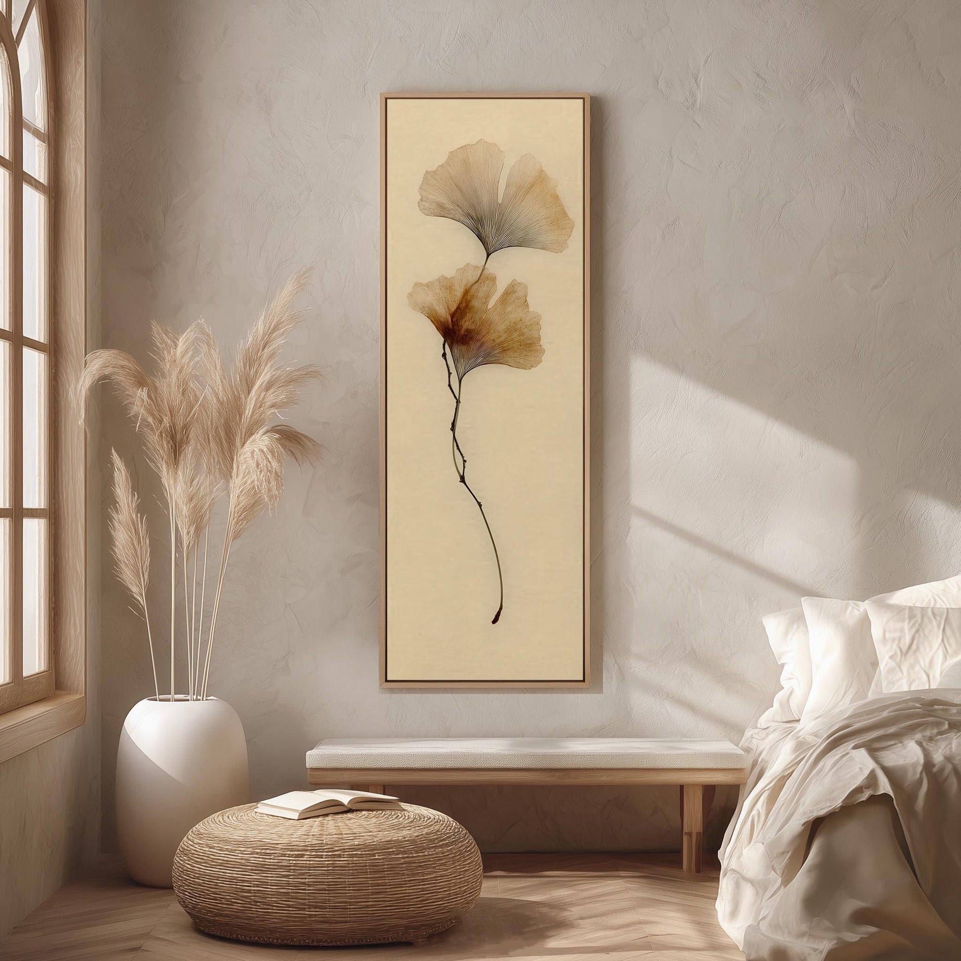 a serene and minimalist bedroom interior, featuring a large framed artwork of a plant on the wall, a white bed with a white pillow, a white vase with tall potted plants, and a woven ottoman.