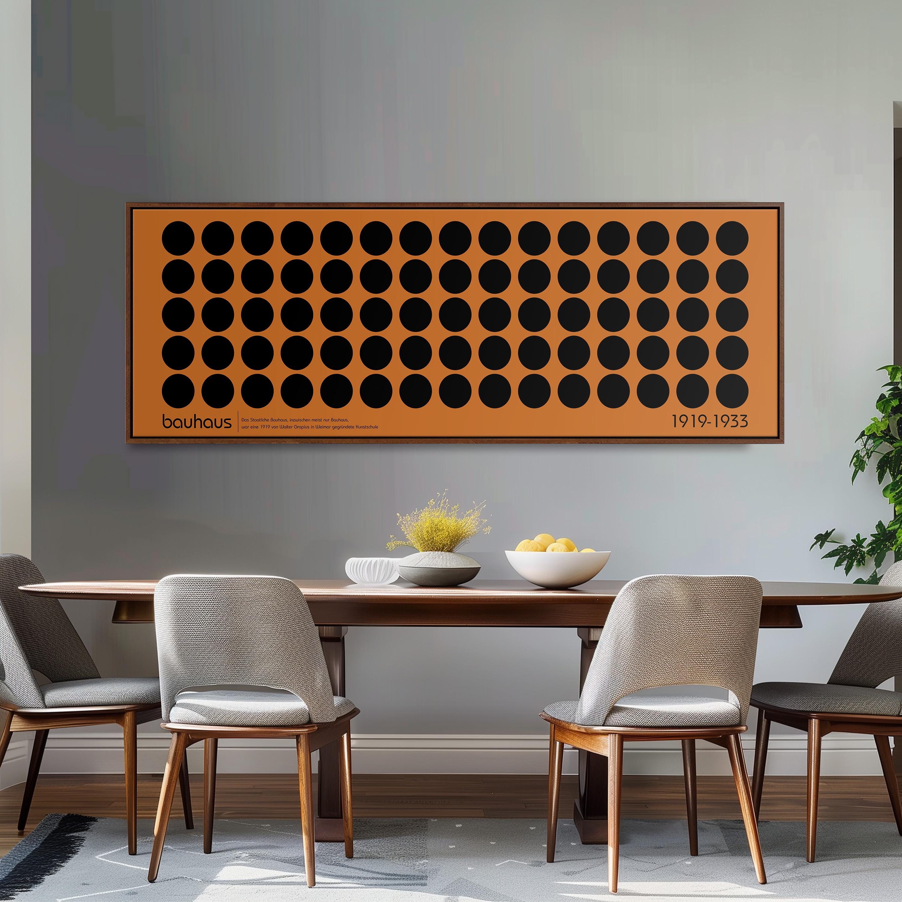 a dining room with a wooden table and four chairs. Above the table, there is a large orange and black circular artwork hanging on the wall. The table is set with a bowl of fruit and a vase of flowers.