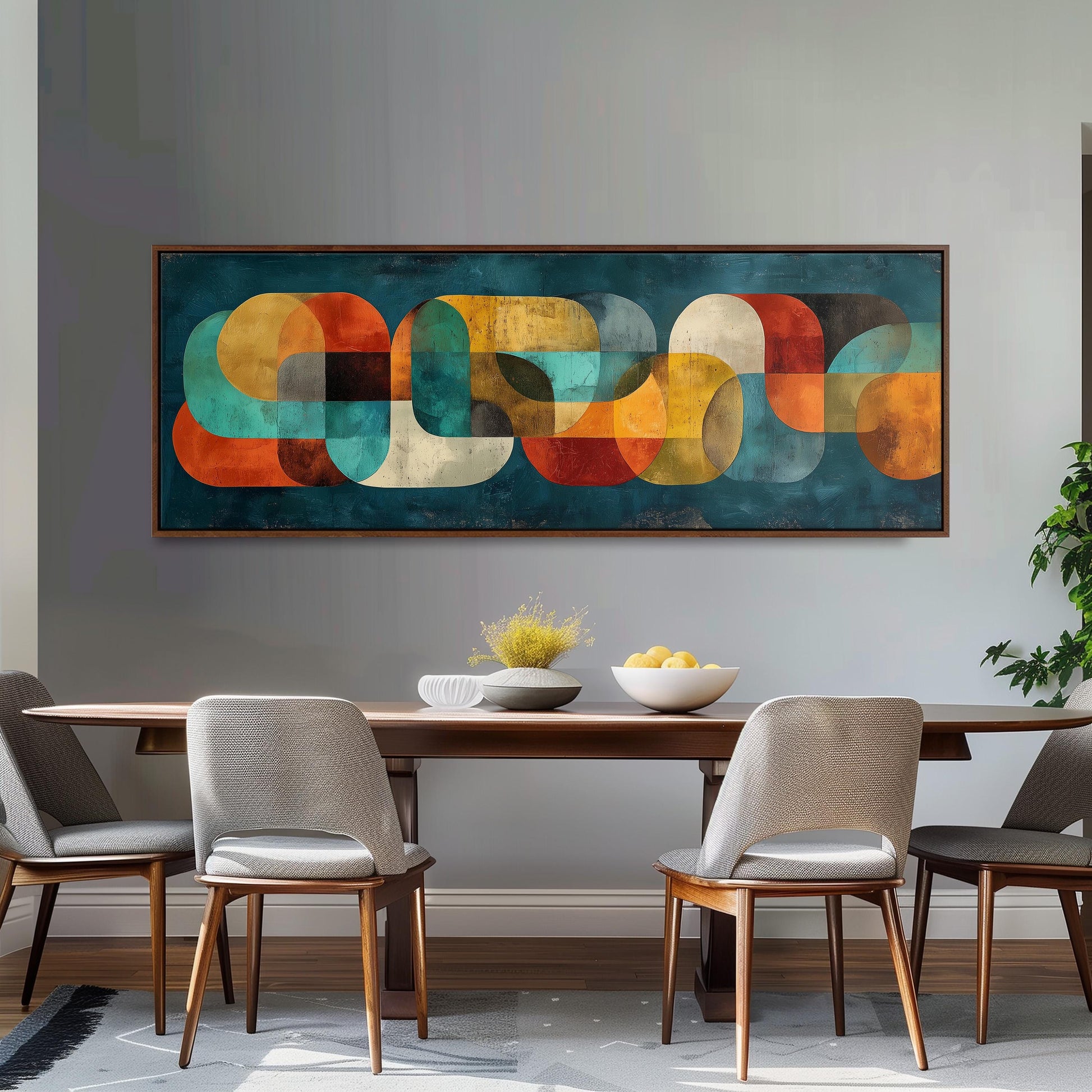 a modern dining room with a large abstract painting hanging on the wall above a wooden dining table with four chairs. The table is set with a bowl of fruit and a vase of flowers, creating a welcoming and stylish atmosphere.