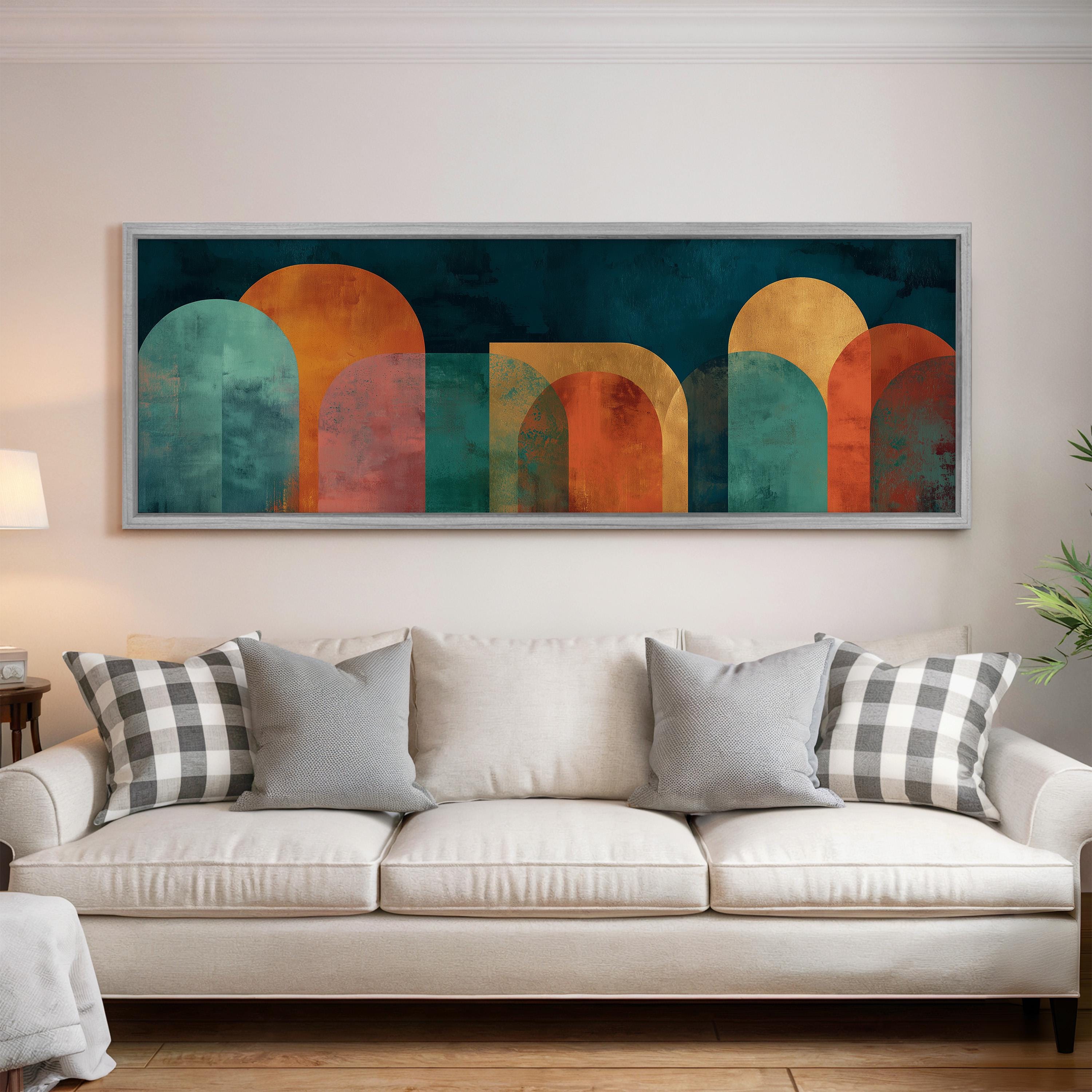a large abstract painting hanging on a wall above a white couch with gray and black plaid throw pillows.