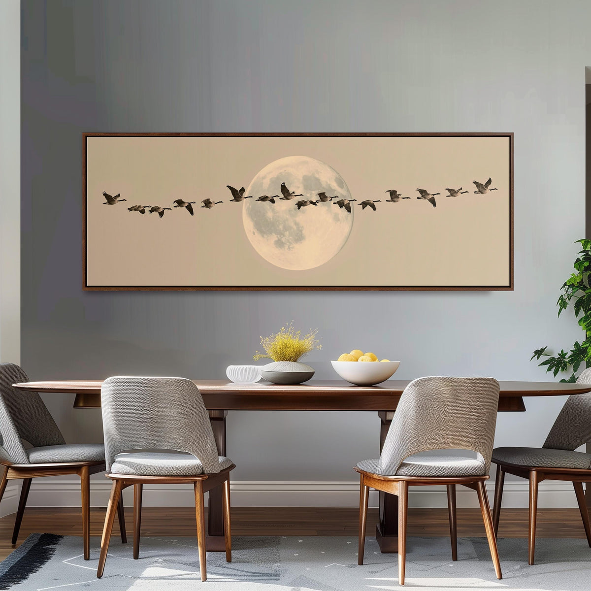 Geese flying across a pale moon on sand long horizontal canvas print above a dining table