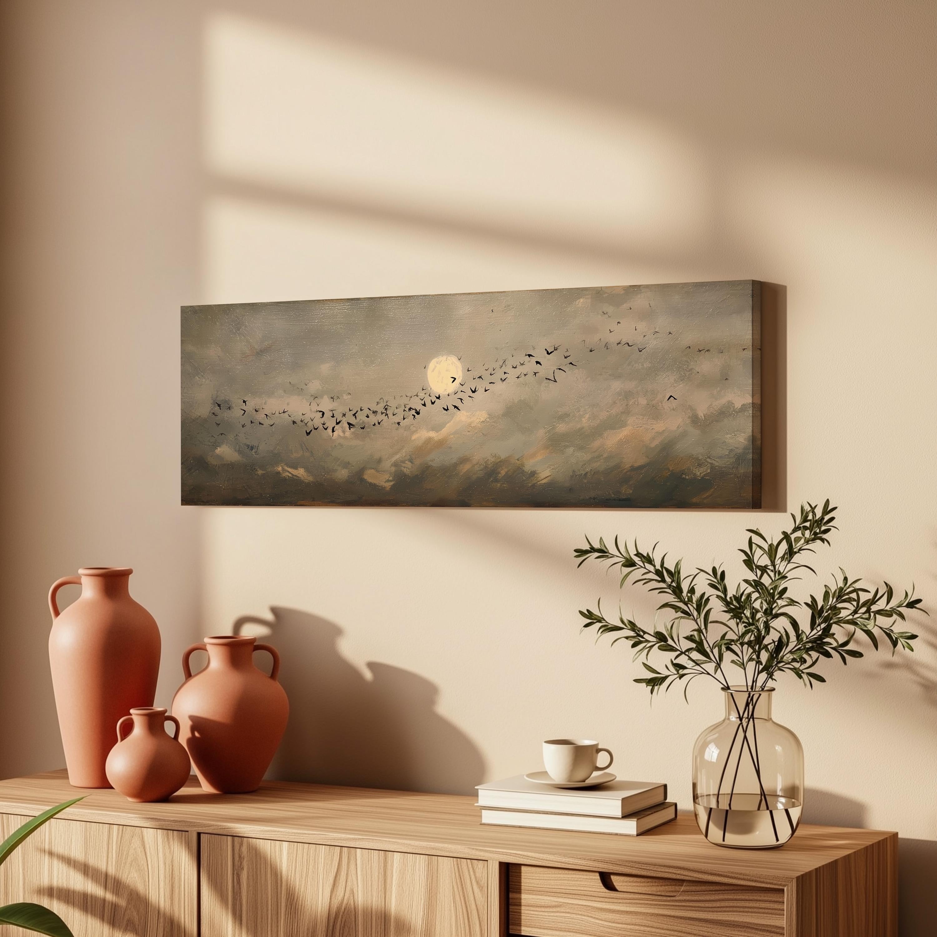 a wooden cabinet with a painting of a flock of birds in flight, a vase with greenery, and a stack of books on top.