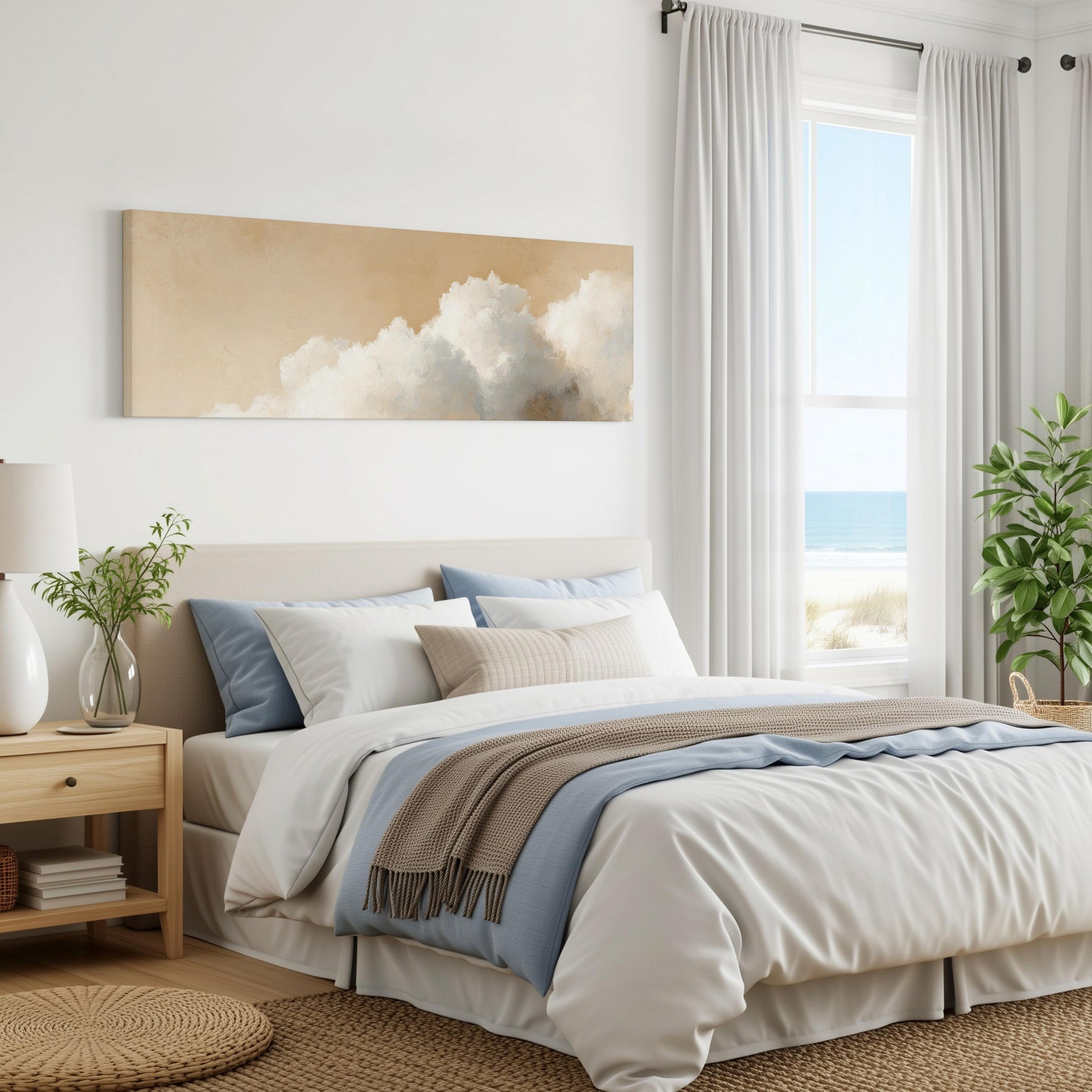 a serene and modern bedroom with a large bed, a nightstand, and a painting of clouds on the wall. The room has a neutral color scheme with white walls, a beige bedspread, and a blue throw blanket. The window offers a view of the ocean, creating a calming and relaxing atmosphere.