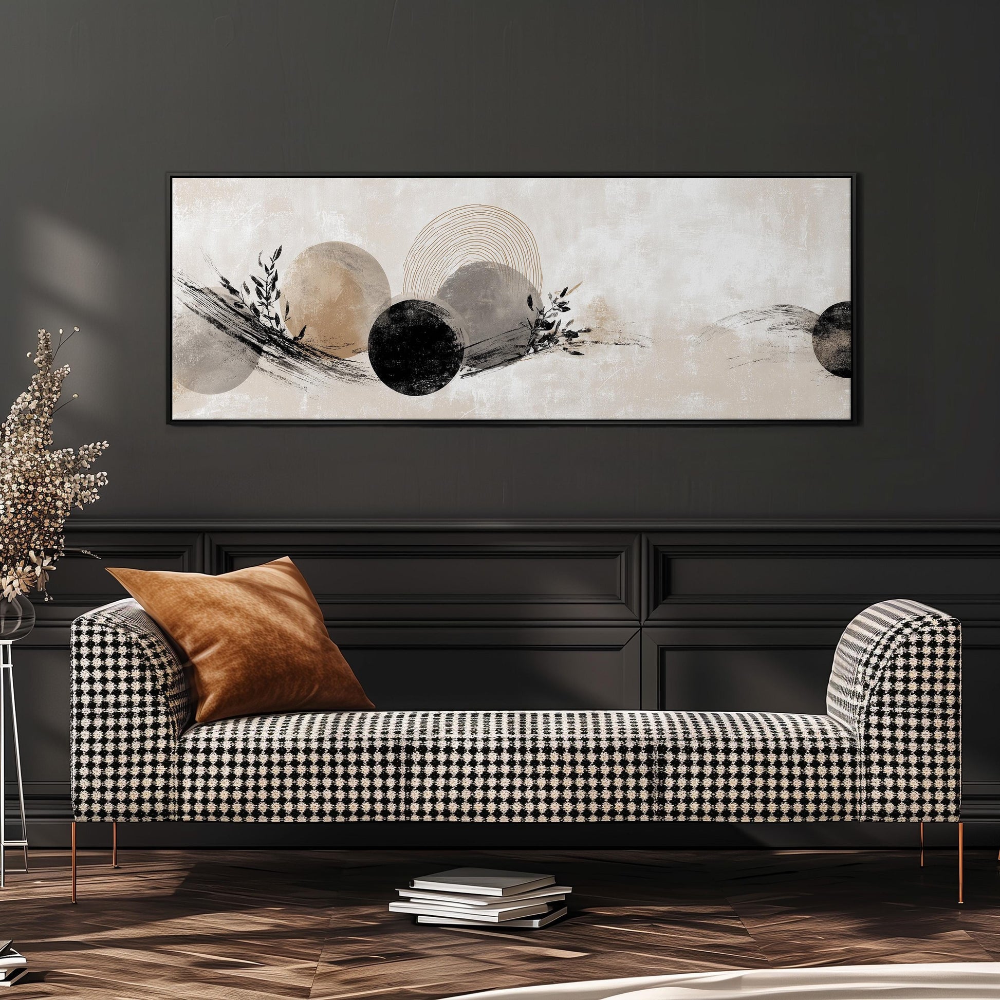 a modern living room with a black and white checkered sofa, a large abstract painting on the wall, and a stack of books on the floor.