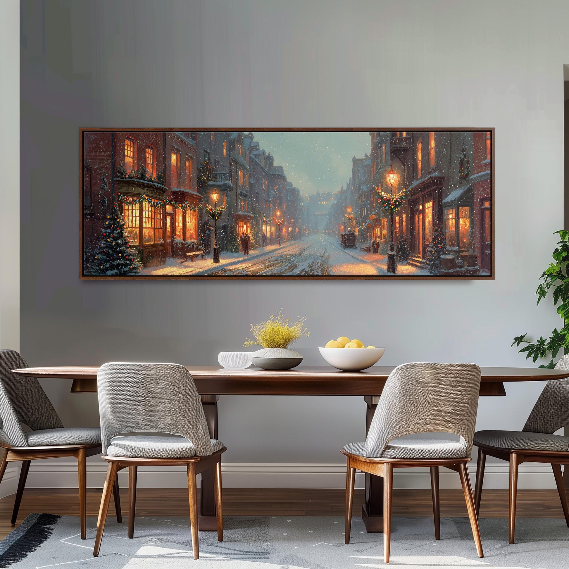a large, framed painting of a snowy city street with buildings, trees, and street lamps, hanging on a wall above a wooden dining table with four chairs.