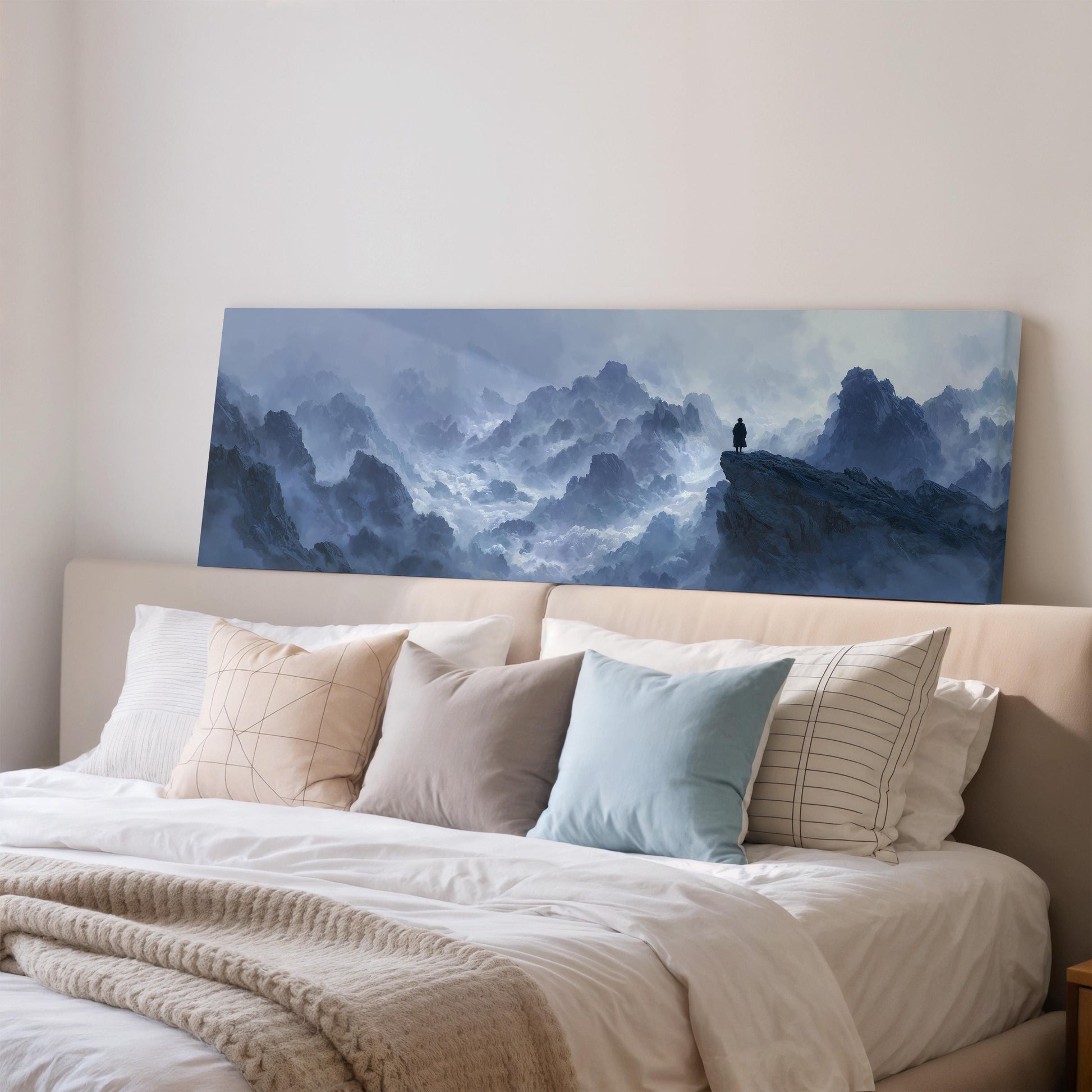 a large, framed painting of a mountainous landscape hanging on a wall above a bed with white bedding and pillows.