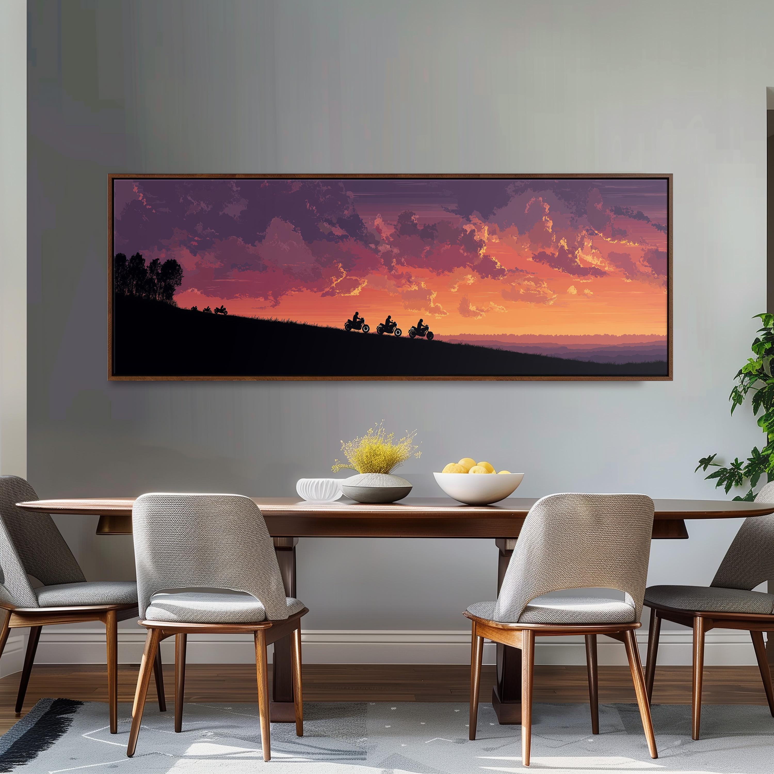 a dining room with a large, framed painting of a sunset landscape hanging on the wall above a wooden dining table with four chairs. The table is set with a bowl of fruit and a vase of flowers, creating a cozy and inviting atmosphere.