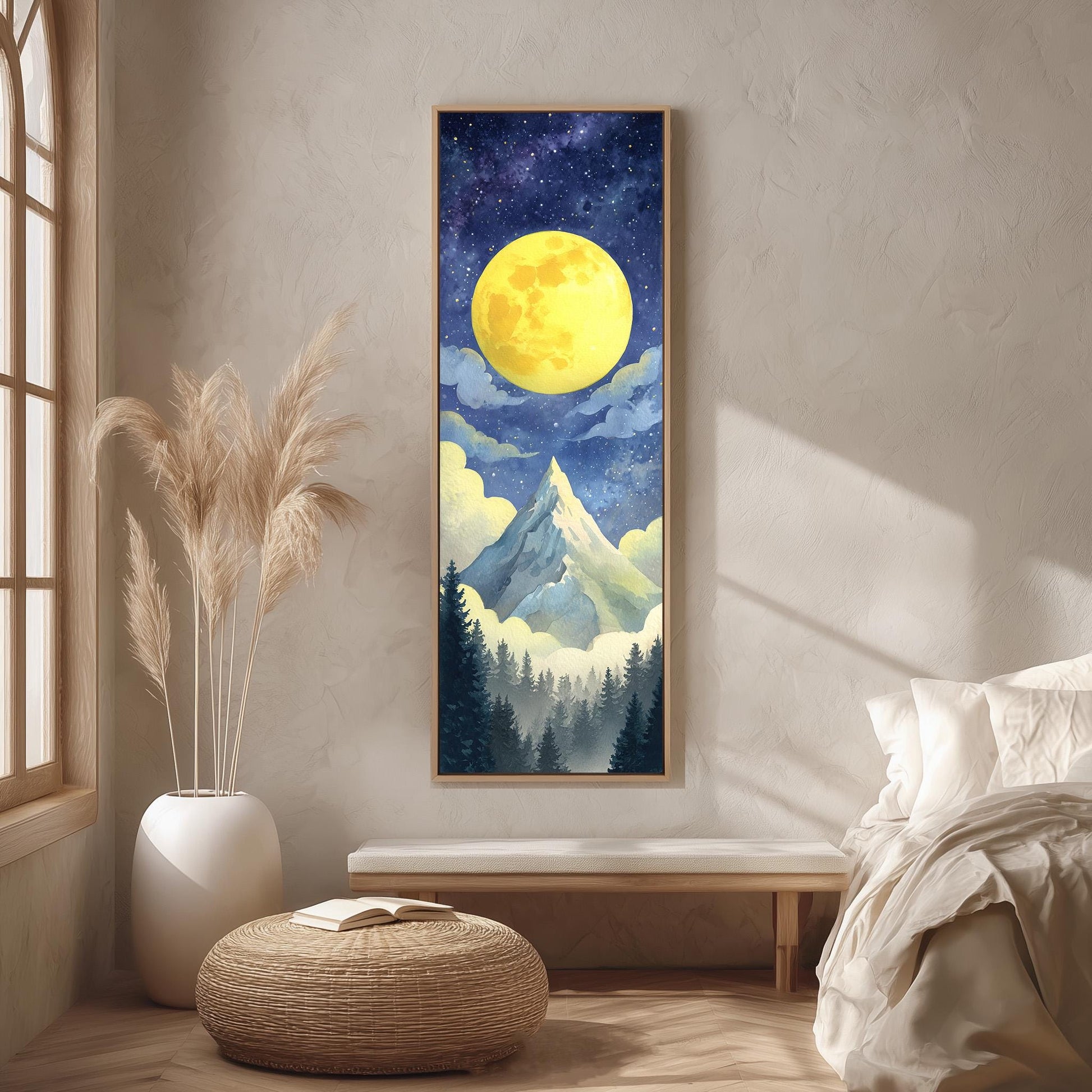 a large painting of a night sky with a large yellow moon, mountains, and clouds, hanging on a wall in a room with a bed, a potted plant, and a woven ottoman.