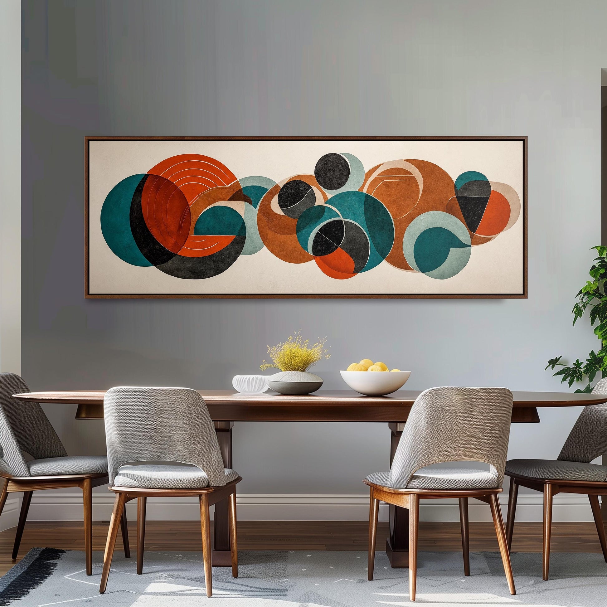 a modern dining room with a large abstract painting hanging on the wall above a wooden dining table with four chairs. The table is set with a bowl of fruit and a vase of flowers, creating a welcoming and stylish atmosphere.