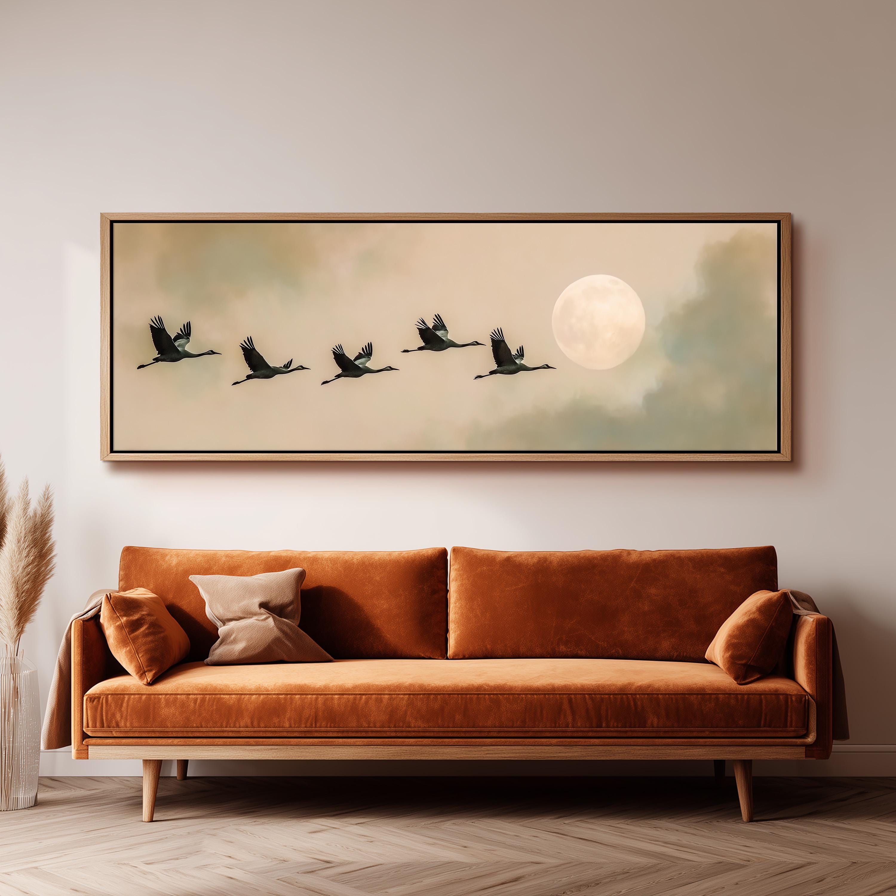 a large framed painting of a flock of birds flying in formation, with a full moon in the background.