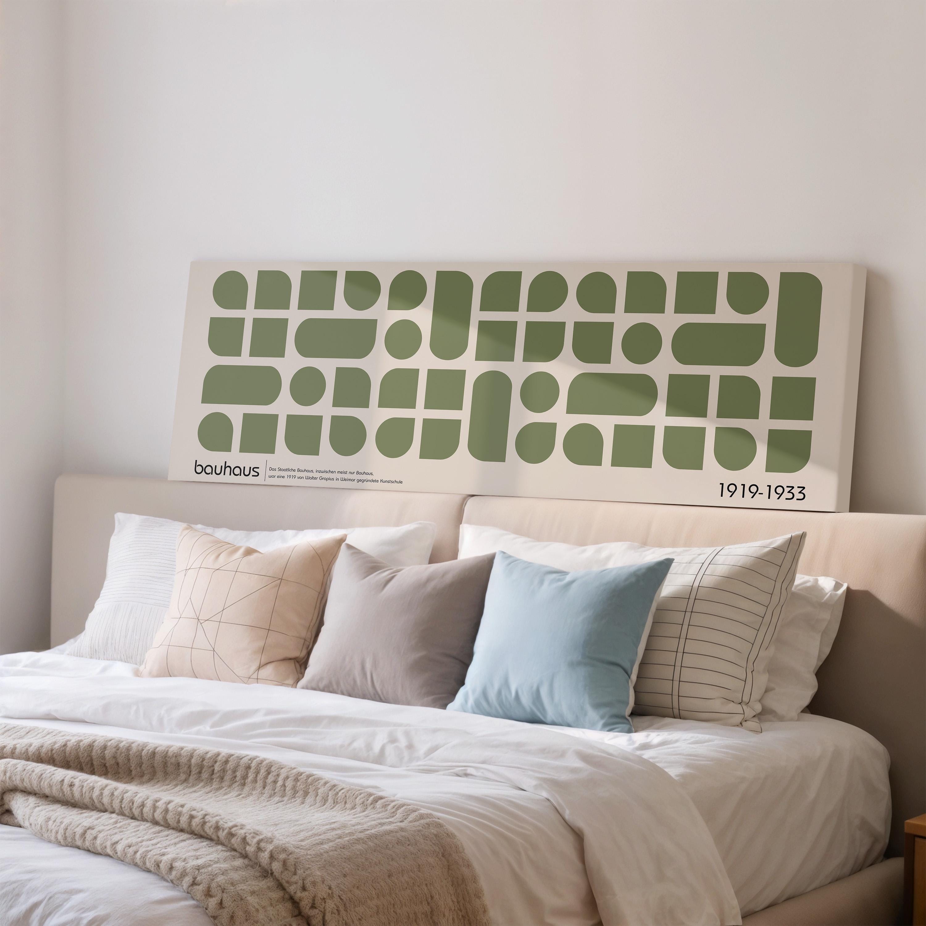 a large bed with a white headboard and a large abstract art piece above it.