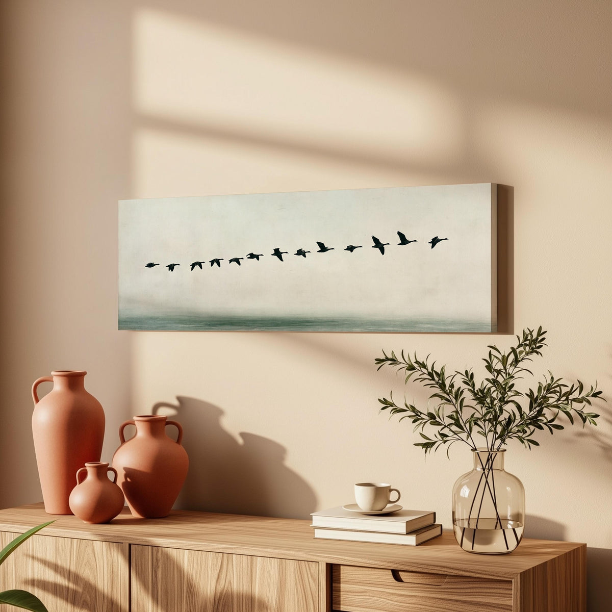 Geese flying over still water long horizontal canvas print above a wooden sideboard