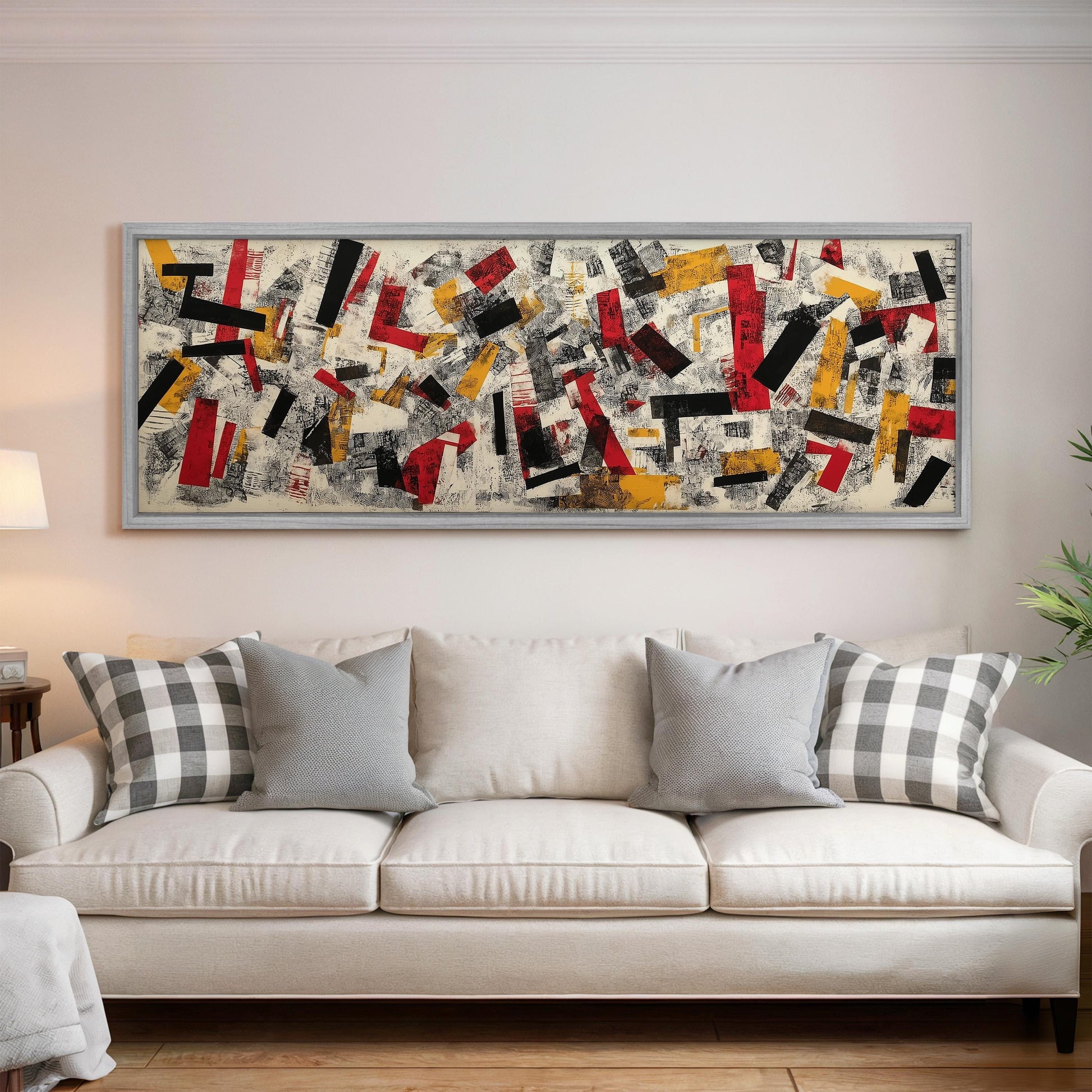 a large abstract painting hanging on a wall above a white couch with gray and white plaid throw pillows.