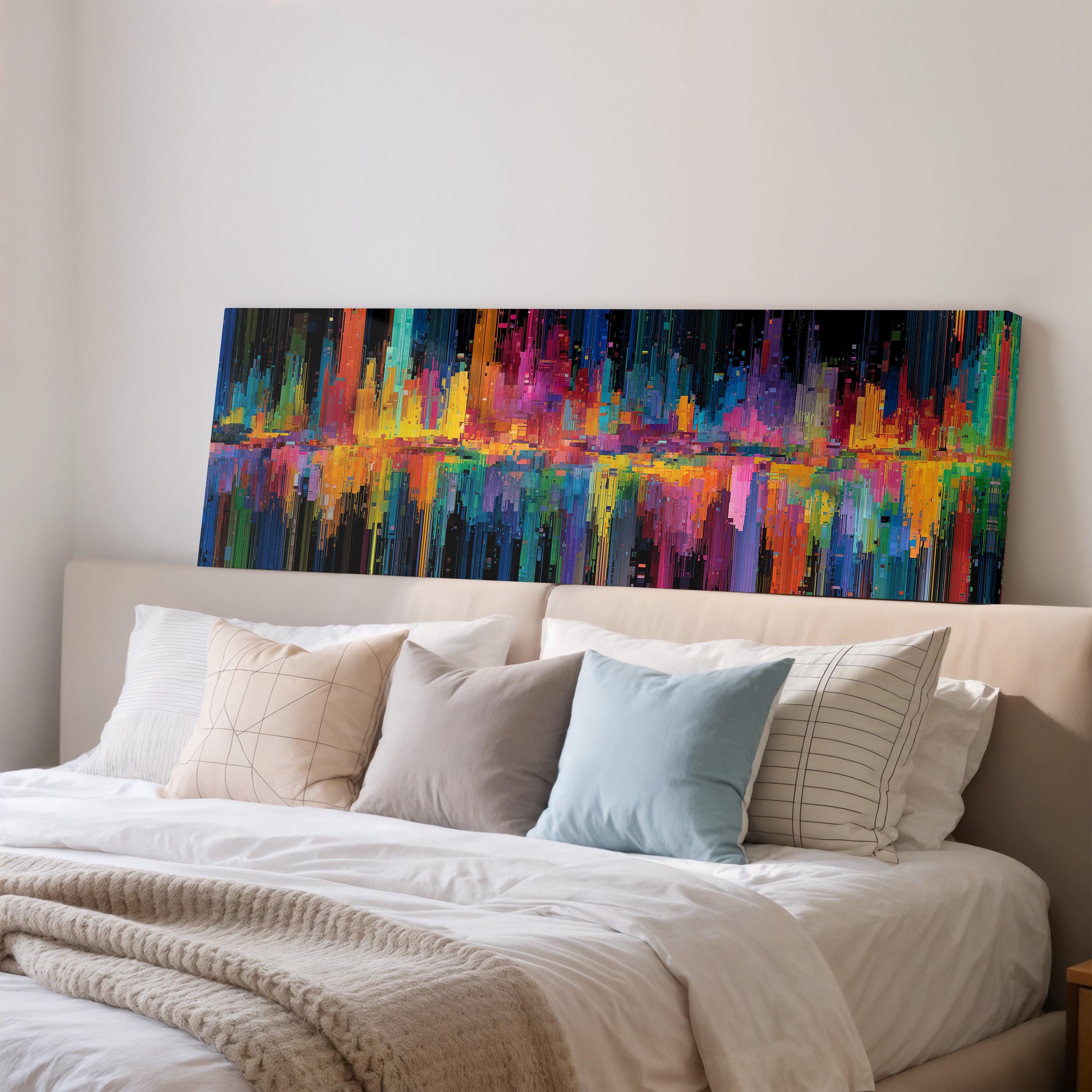 a large, colorful abstract painting hanging on a wall above a bed with white bedding and pillows.