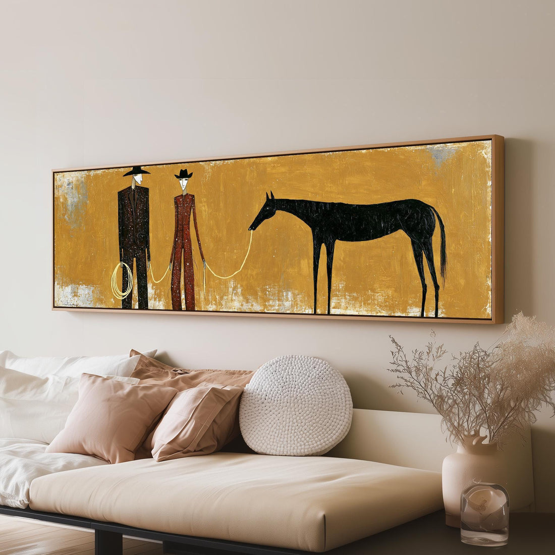 Two cowboys with a dark horse on gold long horizontal canvas print above a sofa in a living room