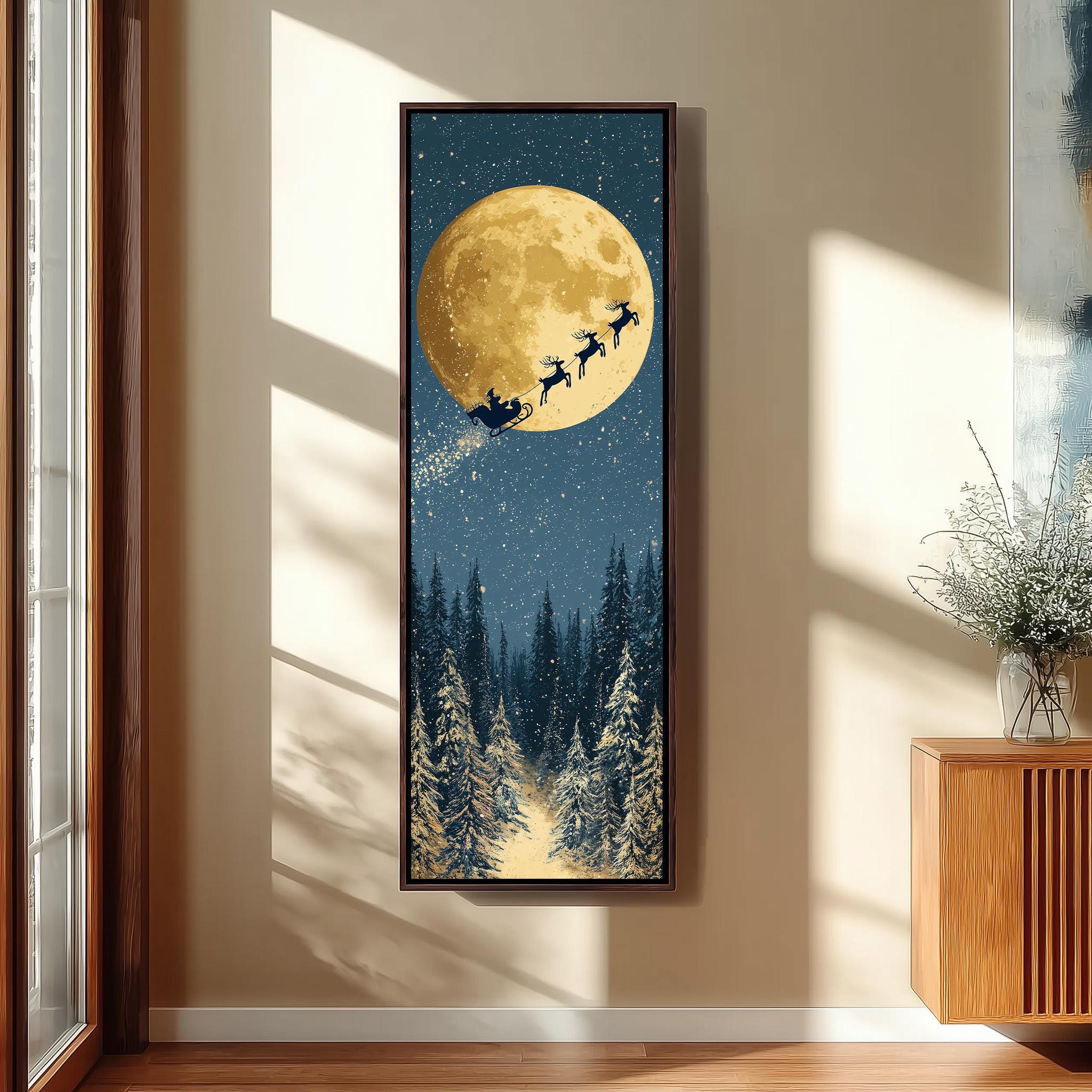 A framed painting depicting a snowy forest scene with a full moon and reindeer flying across the night sky.