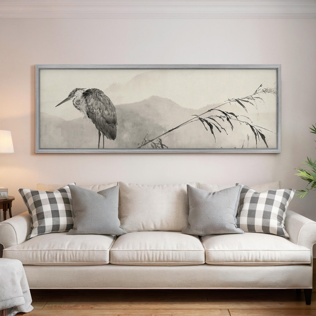Heron in front of misty ink mountains panoramic canvas print above a white sofa in a bright living room