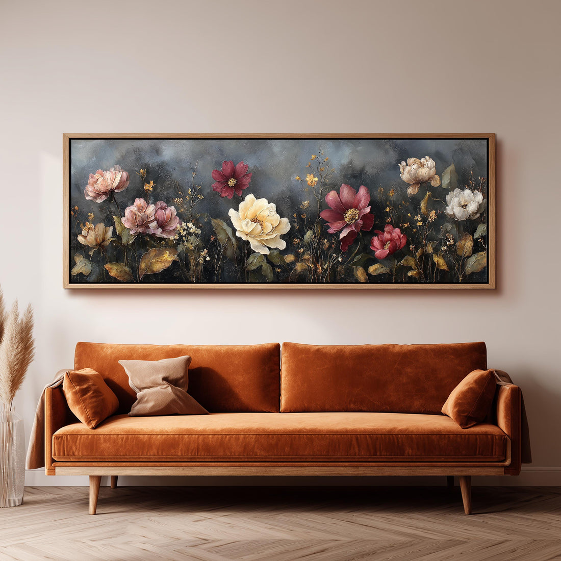 a large, framed painting of flowers hanging on a wall above a brown sofa.