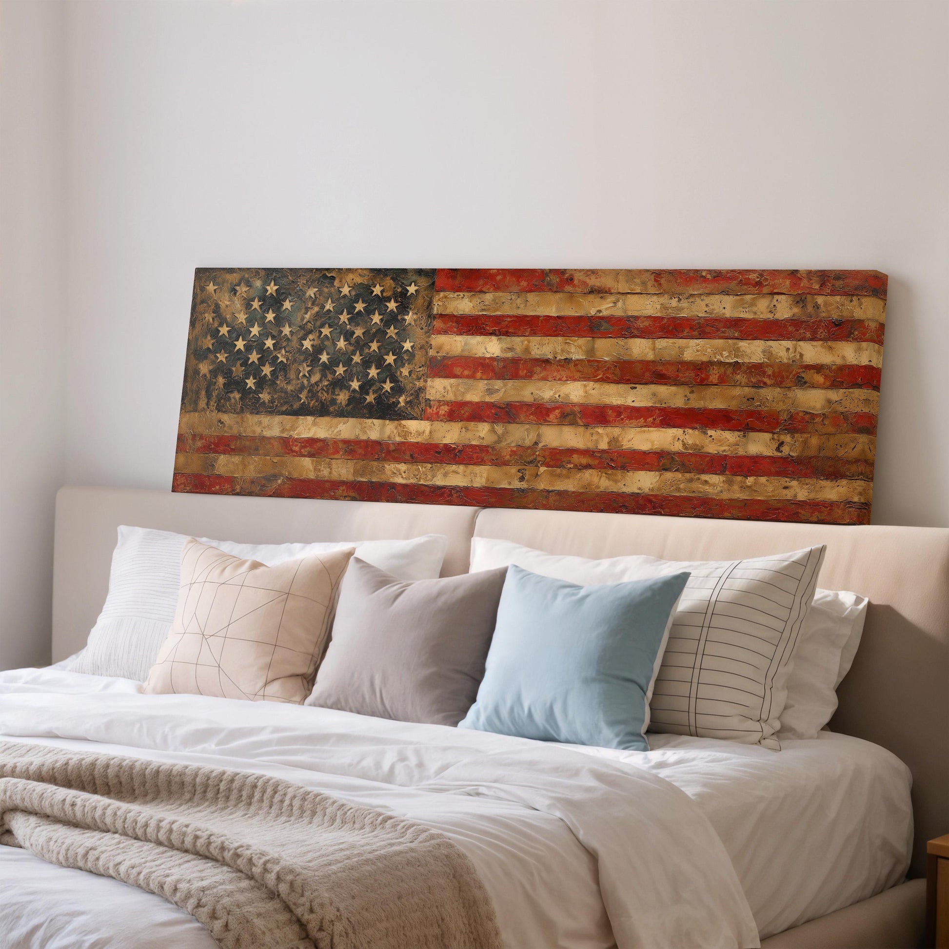 a large American flag displayed on a wall above a bed with white bedding and pillows.